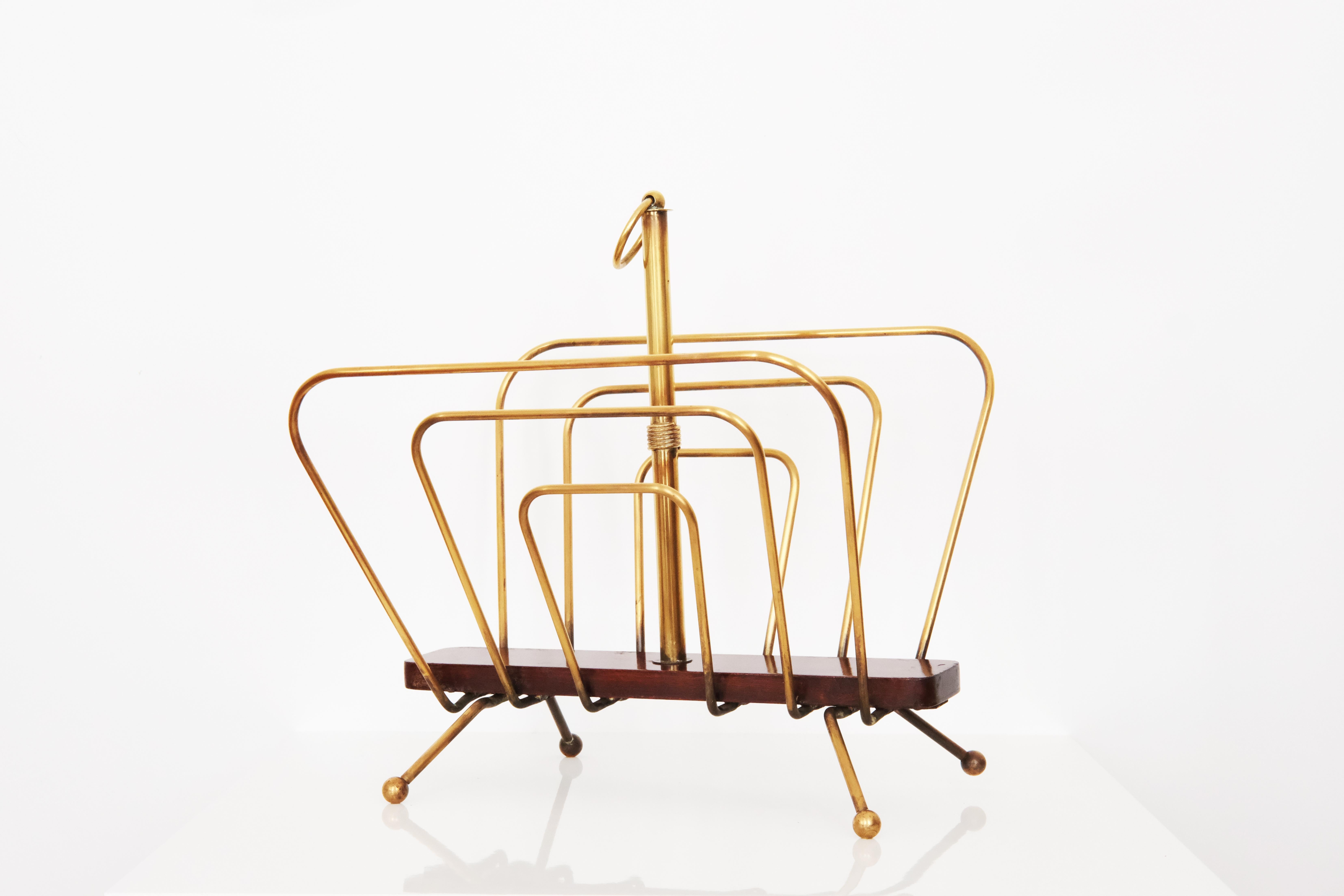This elegant magazine rack, attributed to the renowned French Designer Jacques Adnet, exemplifies his signature blend of modernist functionality and refined luxury. Crafted in brass and wood, the piece features a minimalist yet sophisticated