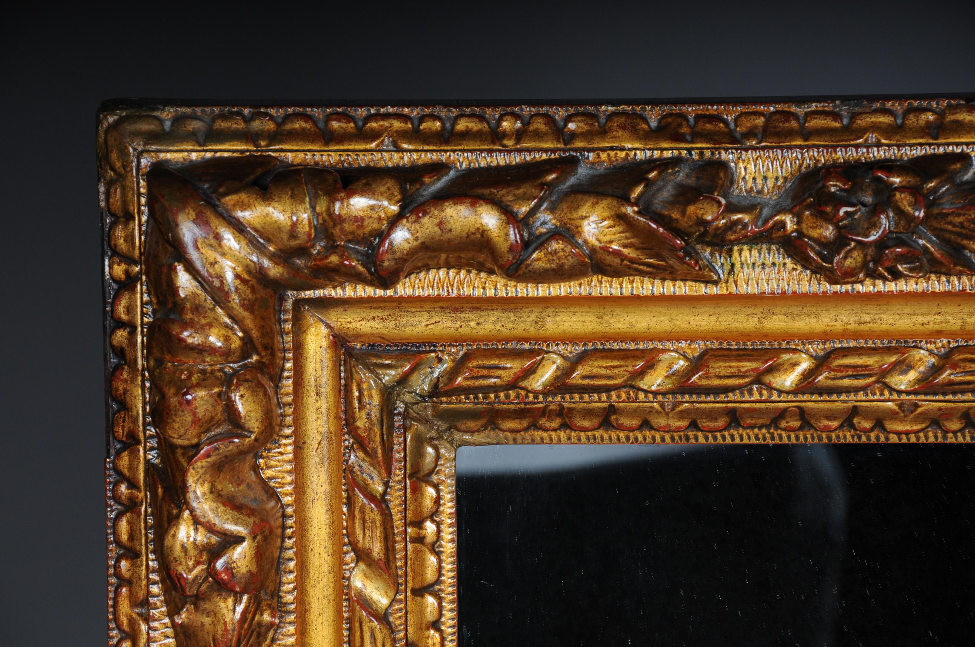 Mirror framed with a richly ornamented baroque frame. Frame completely set in gold.

(M-27).