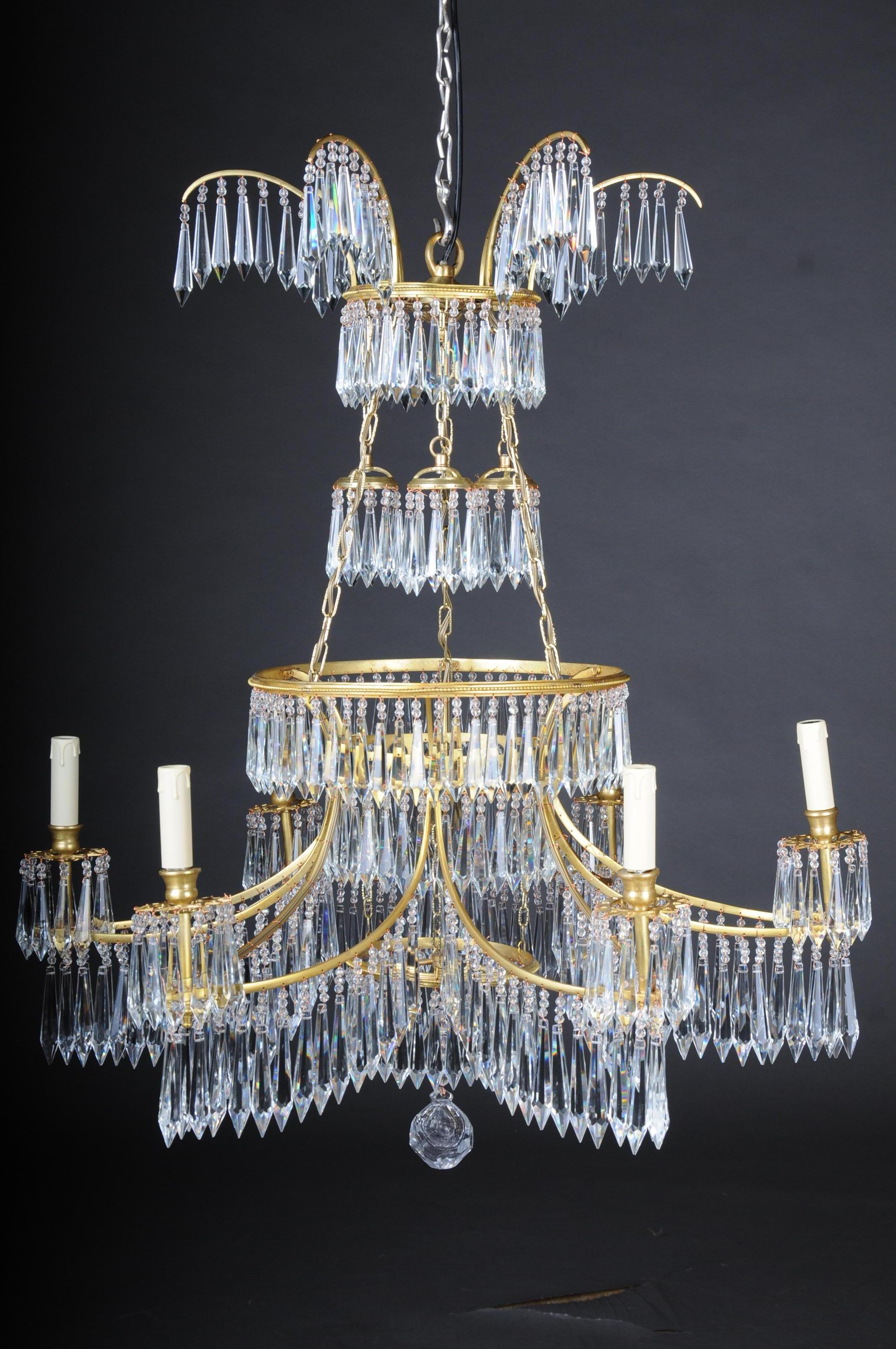 Magnificent, classical Swedish ceiling crown, chandelier

Polished brass. Curved, star shaped body with teardrop-shaped, faceted glass hangings, starting with six light arms, ending as eaves shells. Above the curly, star shaped luster ring, two