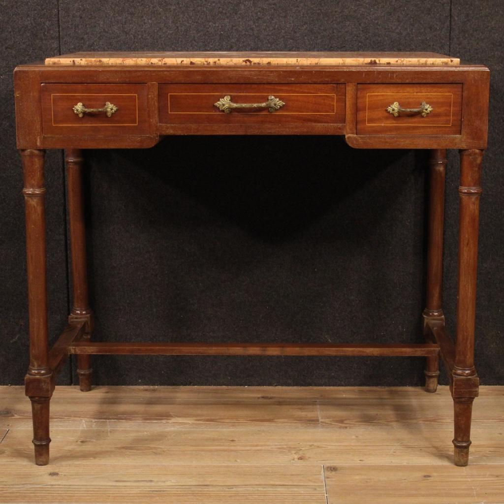 Italian table from the first half of the 20th century. Carved and inlaid furniture in mahogany and maple with decorations in gilded and chiseled bronze. Small desk equipped with three front drawers and recessed marble top of discrete size and