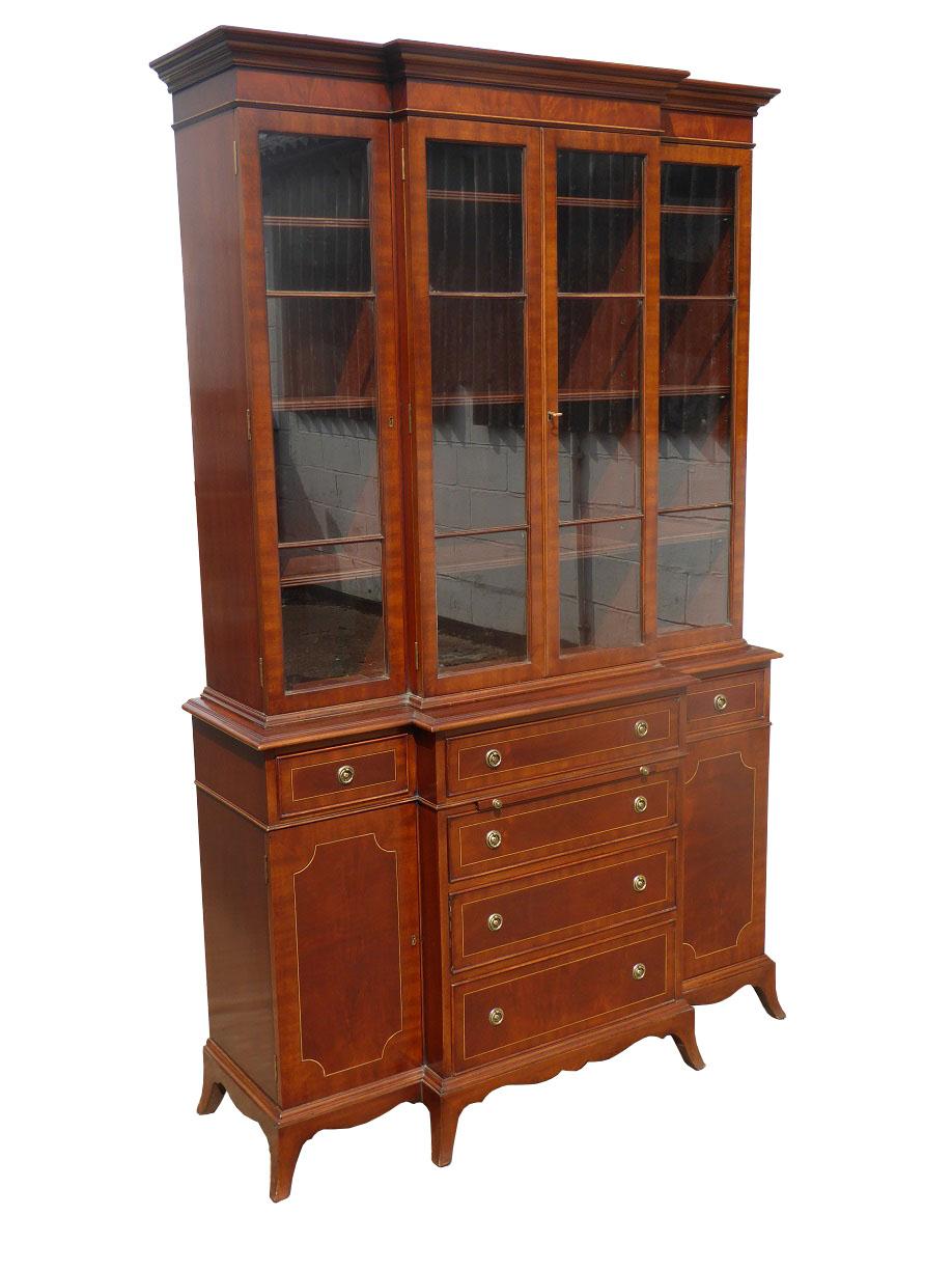 For sale is a good quality four door breakfront bookcase of small proportions. The top of the bookcase has four glazed doors each opening to reveal adjustable shelves. Below this, in the base section, there is a small writing slide, below a single