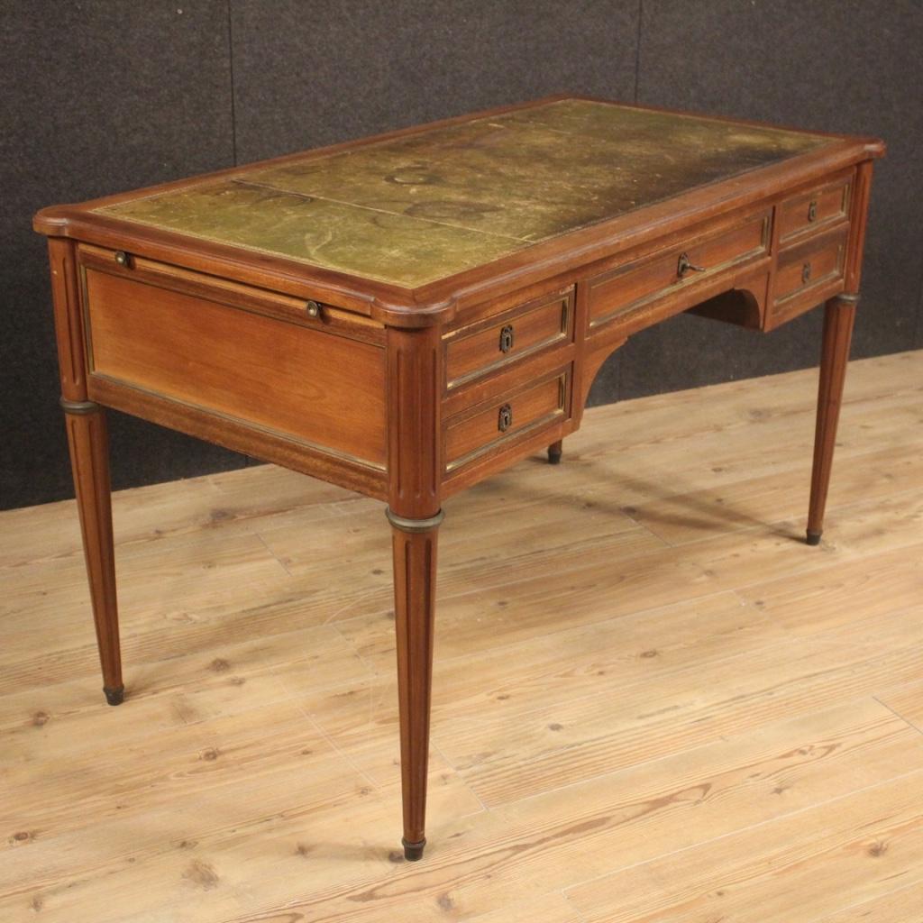 French writing desk from the mid-20th century. Furniture carved and veneered in mahogany, cherry and beech woods. Desk in beautiful patina with top covered in leather with different signs of wear that give even more charm to the furniture. Desk