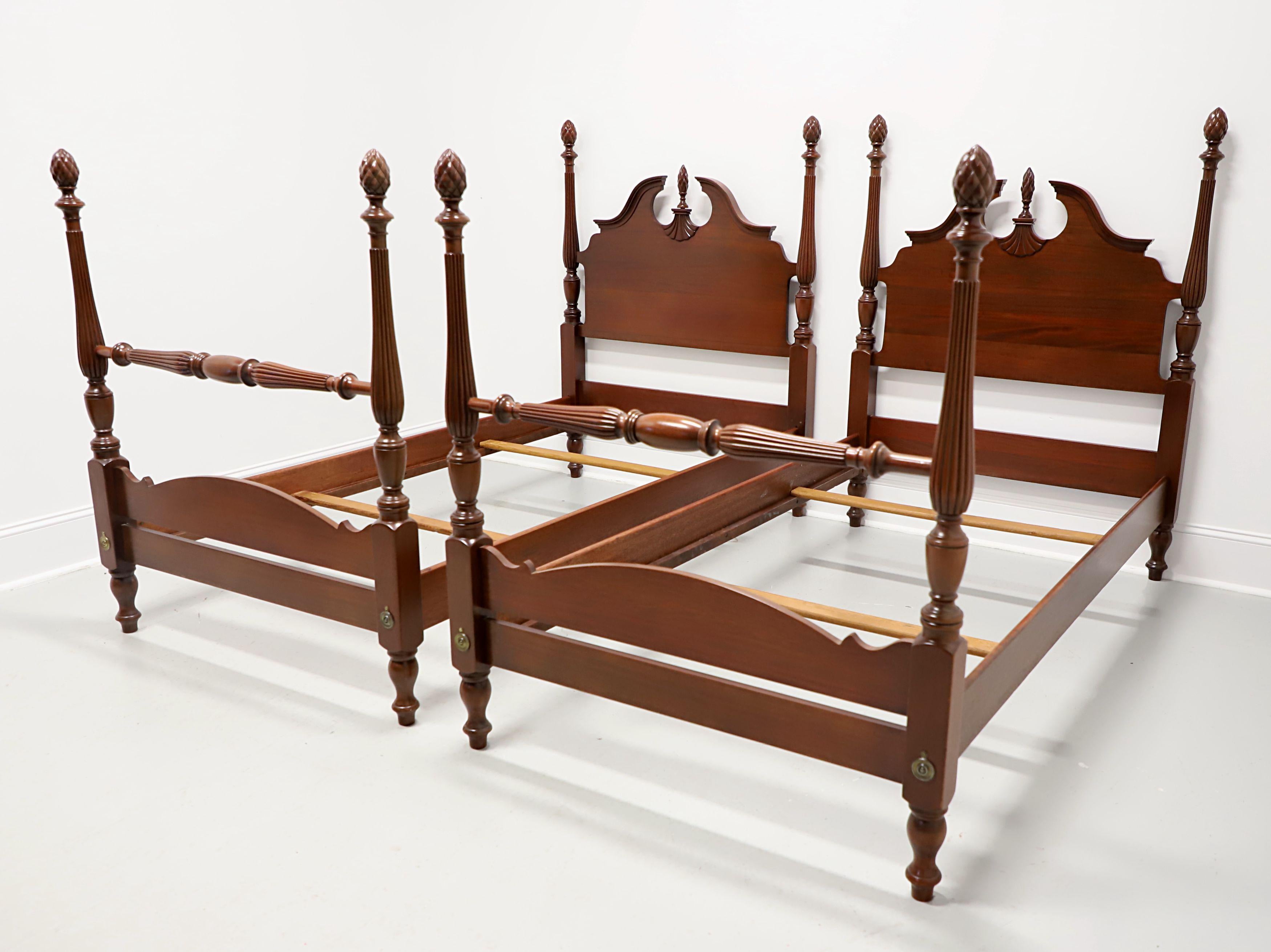 A pair of Chippendale style twin size short poster beds, unbranded. Solid mahogany, headboard with carved pediment & center finial, decorative carvings, four fluted & turned short posts capped by pineapple finials, footboard with turned post detail,