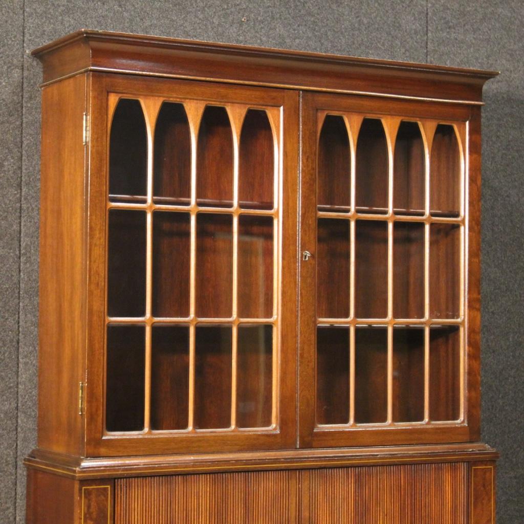 Particular English bookcase / writing desk from 20th century. Furniture carved and inlaid in mahogany, maple and fruitwood of beautiful lines and pleasant decor. Bookcase equipped with two external drawers in the lower part, an opening desk top (see