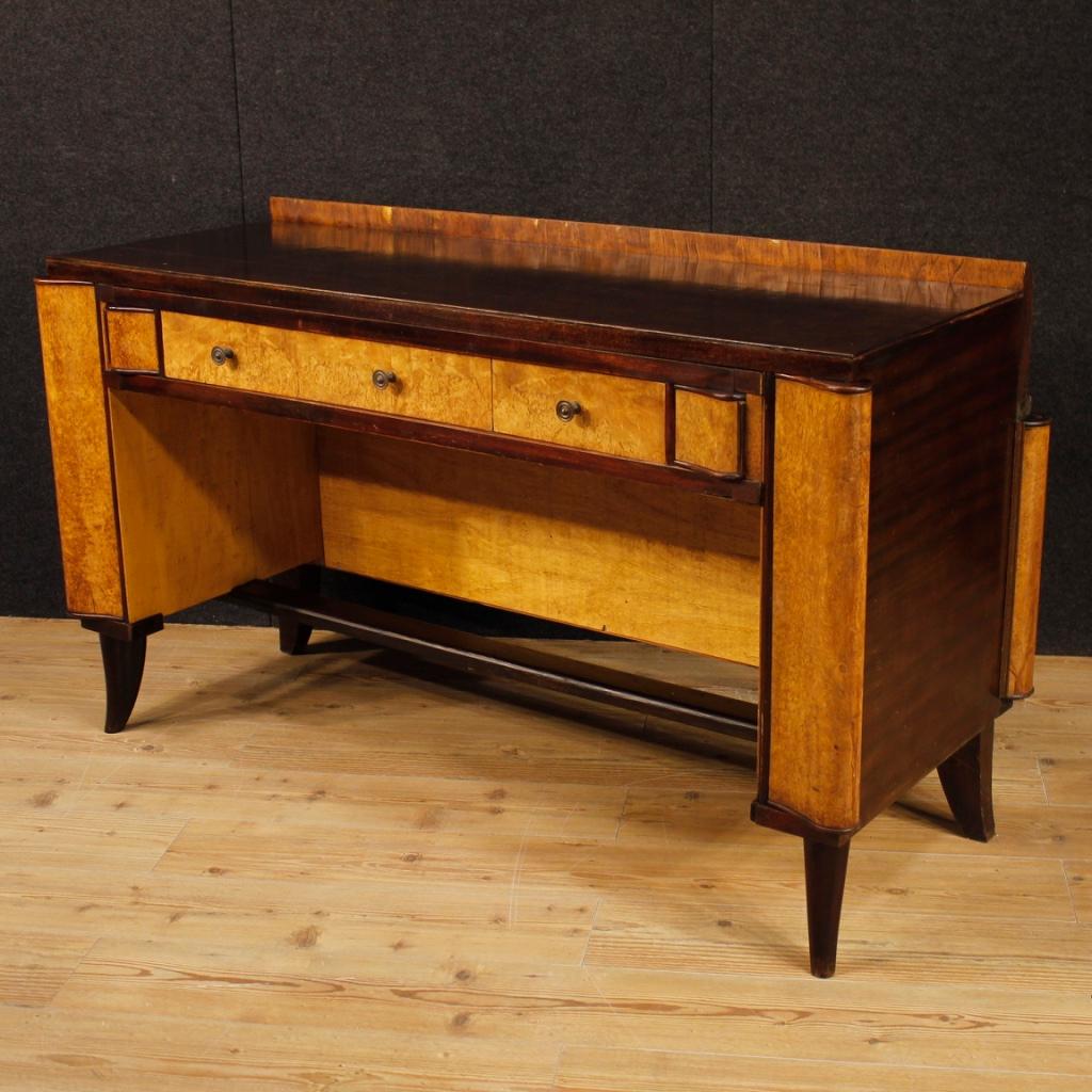Italian writing desk from the mid-20th century. Particularly shaped furniture, finished for the center in carved mahogany, tuja burl, beech and fruitwood. Desk with three front drawers with wooden top of excellent service. Furniture equipped with a