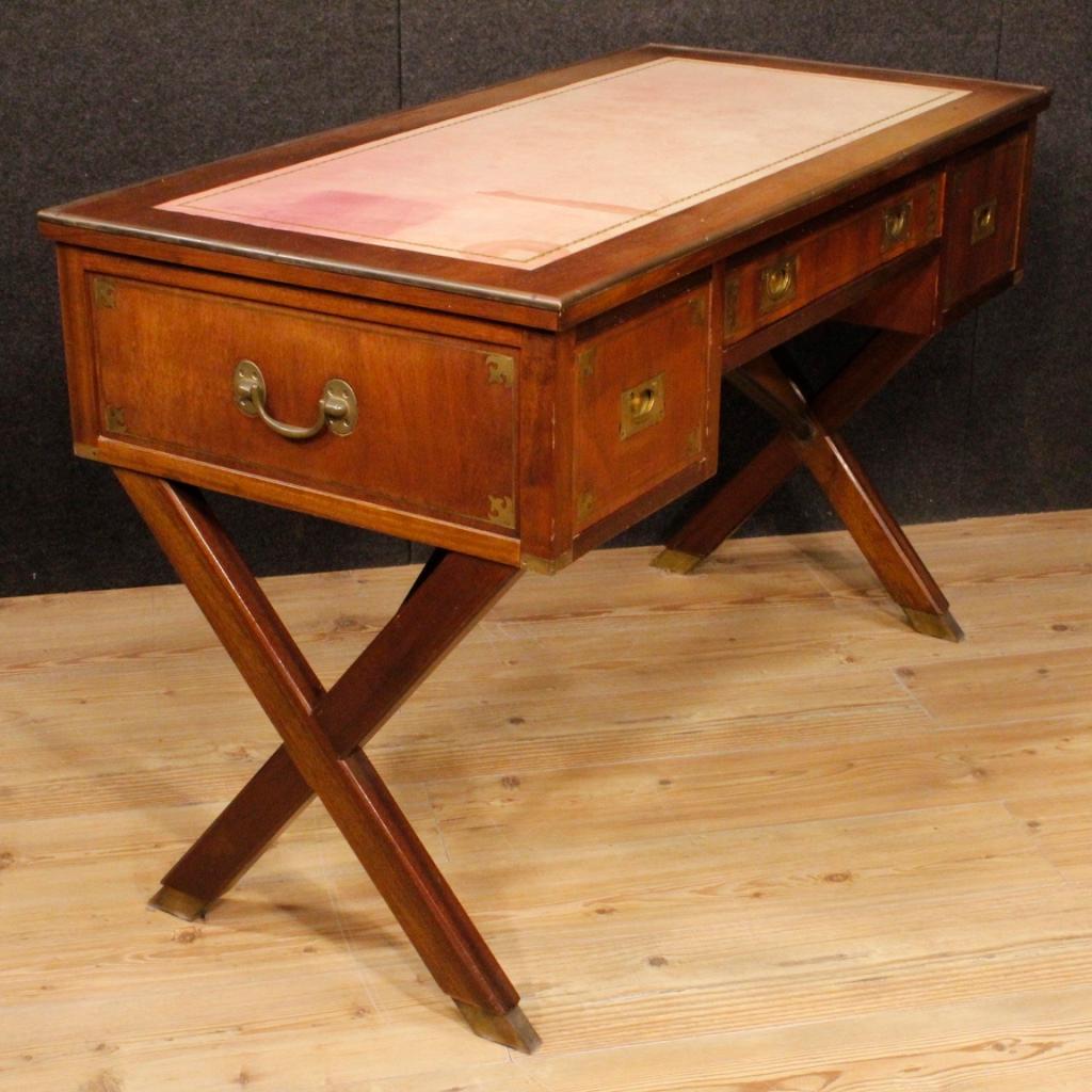 English writing desk from 20th century. Furniture carved in mahogany wood with decorations in golden brass of good quality. Desk finished for the center equipped with three front drawers and top covered in faux leather with some signs of wear (see