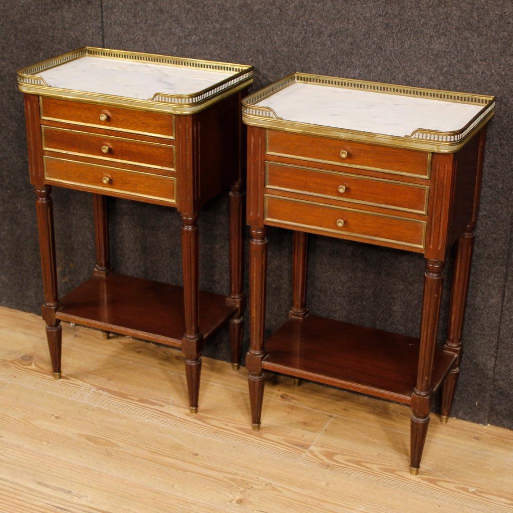 Pair of French bedside tables from 20th century. Furniture carved in mahogany wood, adorned with brass decorations. Bedside tables with recessed marble tops, of good size and service, decorated with gilded and chiseled brass ring. Furniture complete