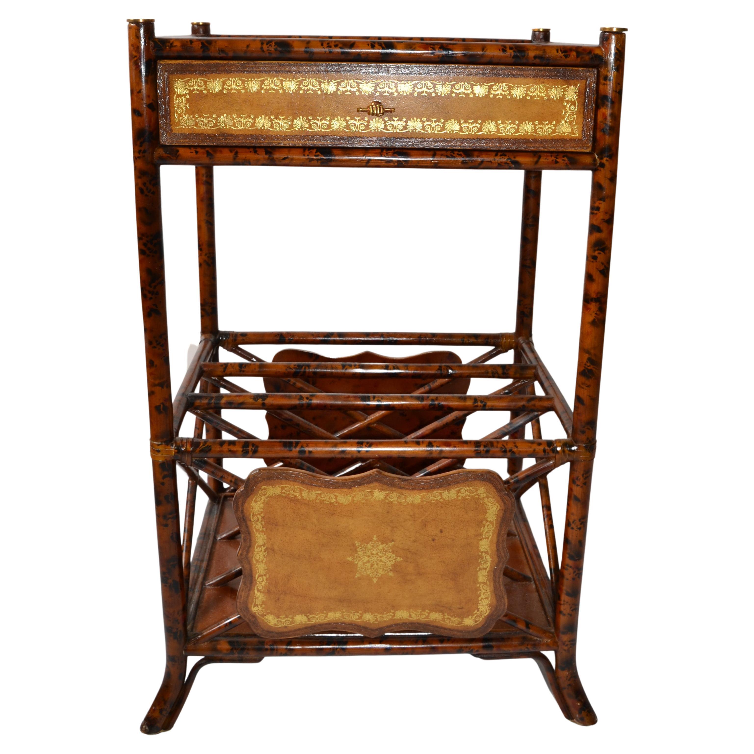 Maitland-Smith British Colonial Style End Table or stand with a faux tortoise finish over a turned wood faux bamboo frame.
Featuring Gold Leaf tooled brown leather panels, one drawer with distinctive Hand Brass Pull Hardware, Magazine racks and