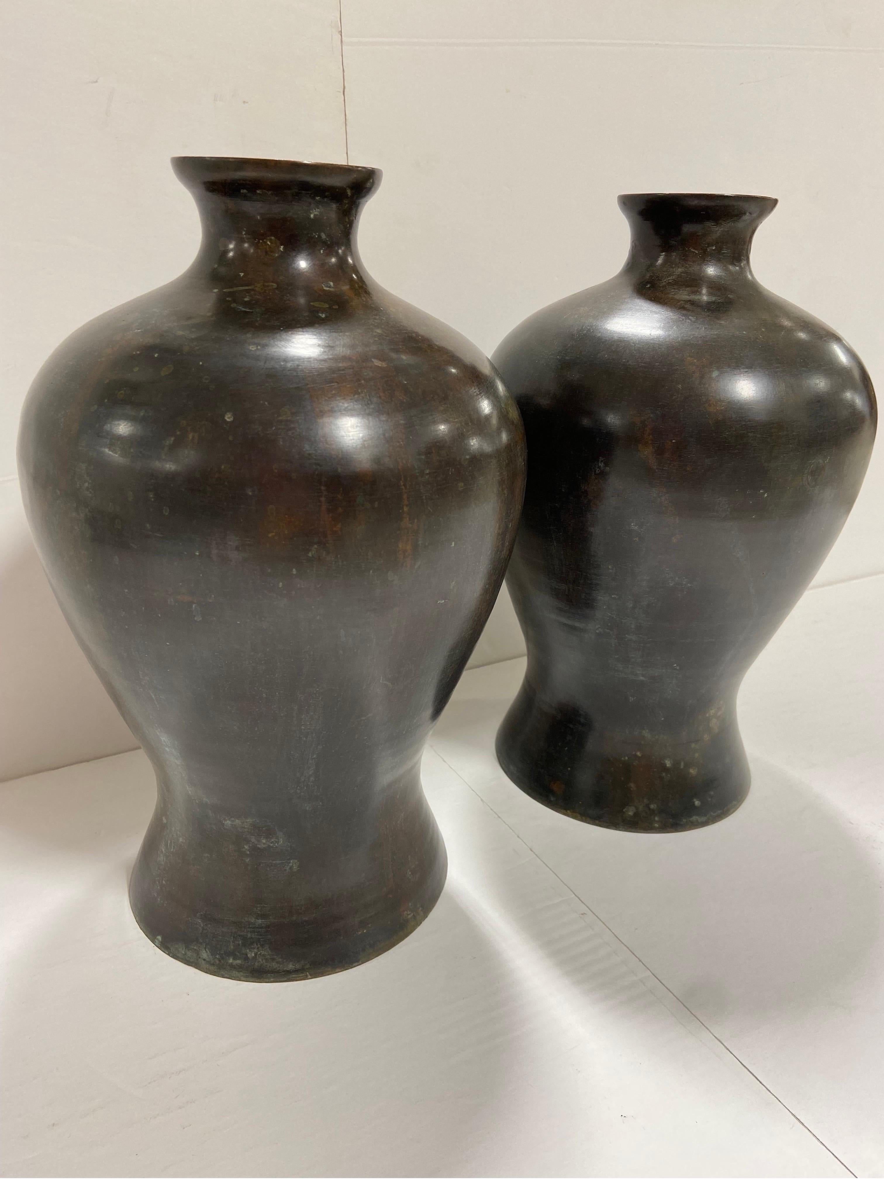 A vintage pair of bronze vases by Maitland Smith. Original labels are underneath. This pair is in the style of Japanese Meiji period bronze works of art. From the Maitland-Smith website, 