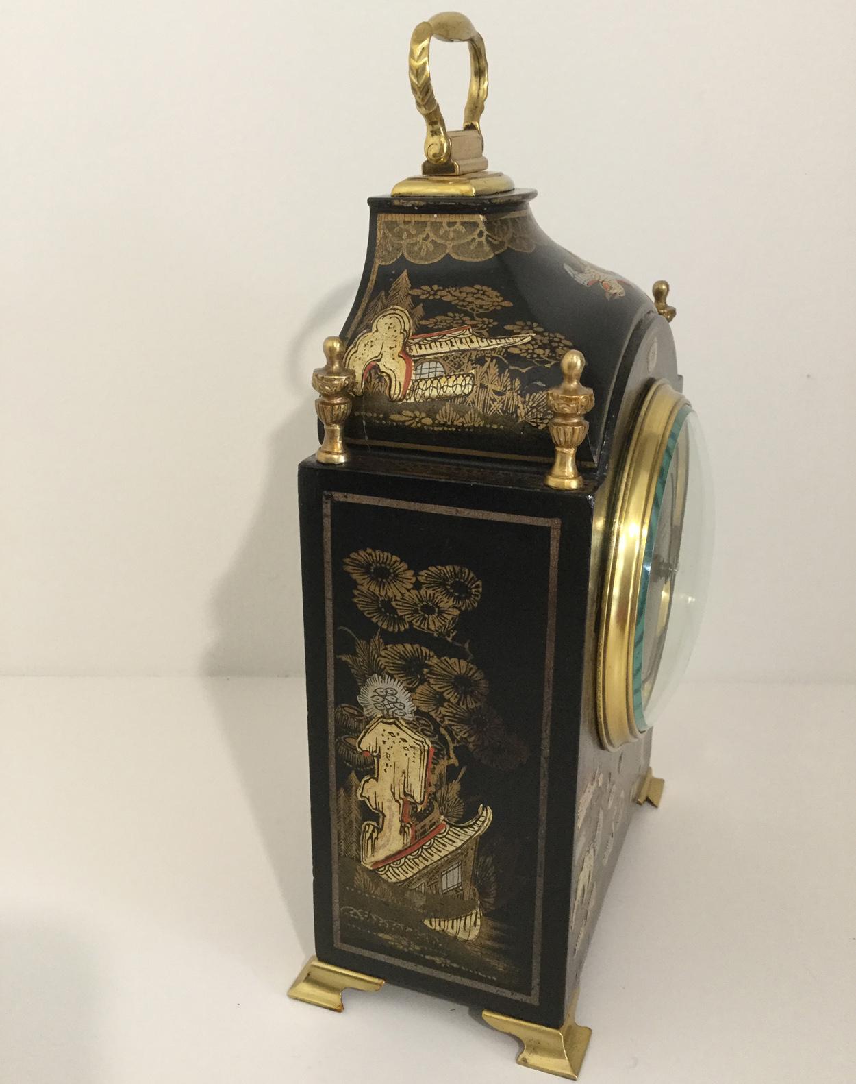 A highly decorative small black chinoiserie bracket clock, circa 1920, the case profusely decorated in relief with maidens, floral, bird and garden scenes, the swept top with four brass finials and a brass loop handle, on brass ogee feet. The gold