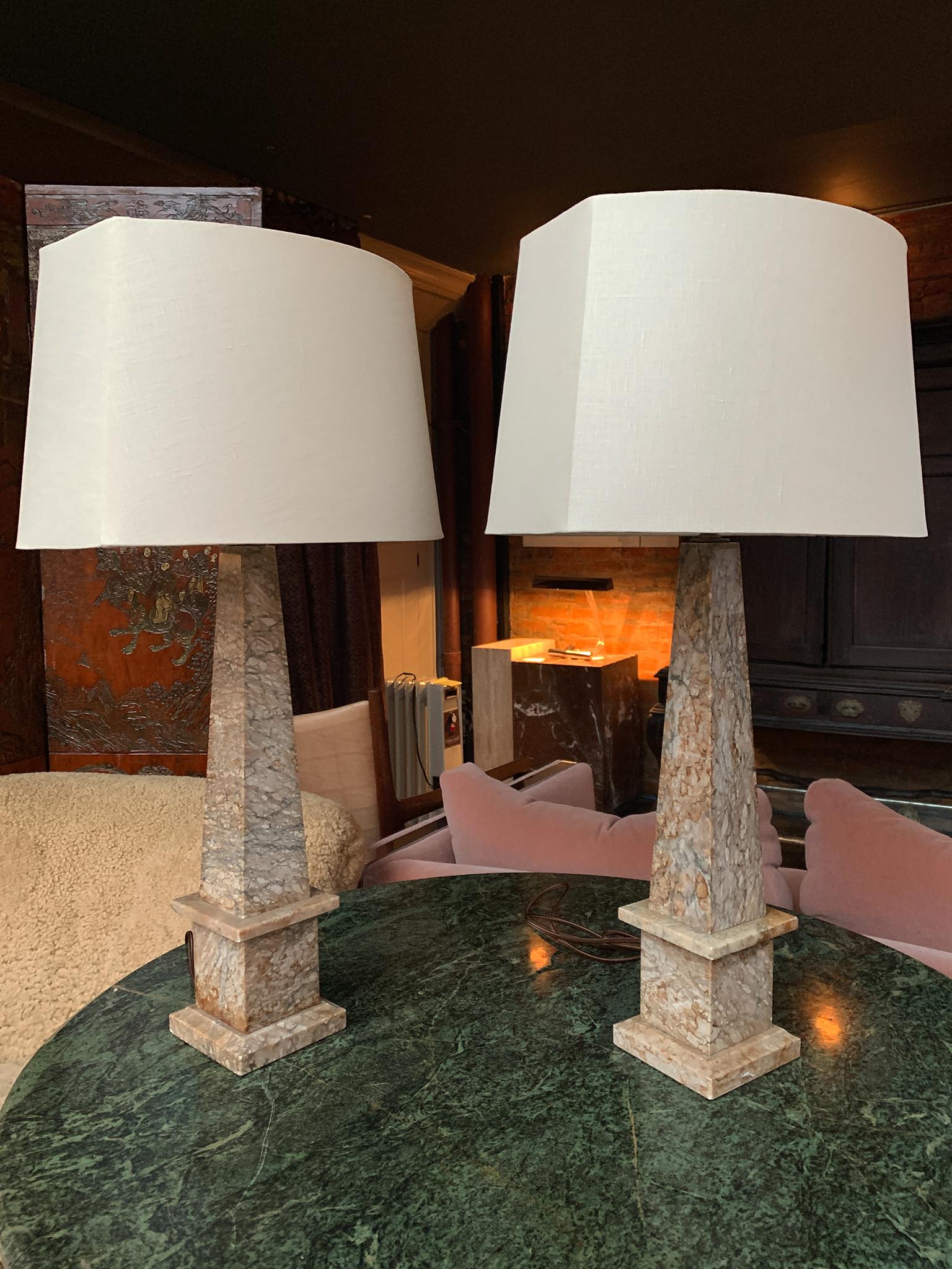 Ces lampes de table en marbre en forme d'obélisque ont été refaites à neuf et sont dotées de douilles à une ampoule. Ils sont équipés de nouvelles harpes et associés à des abat-jour en lin personnalisés. Le marbre présente une palette de beige avec