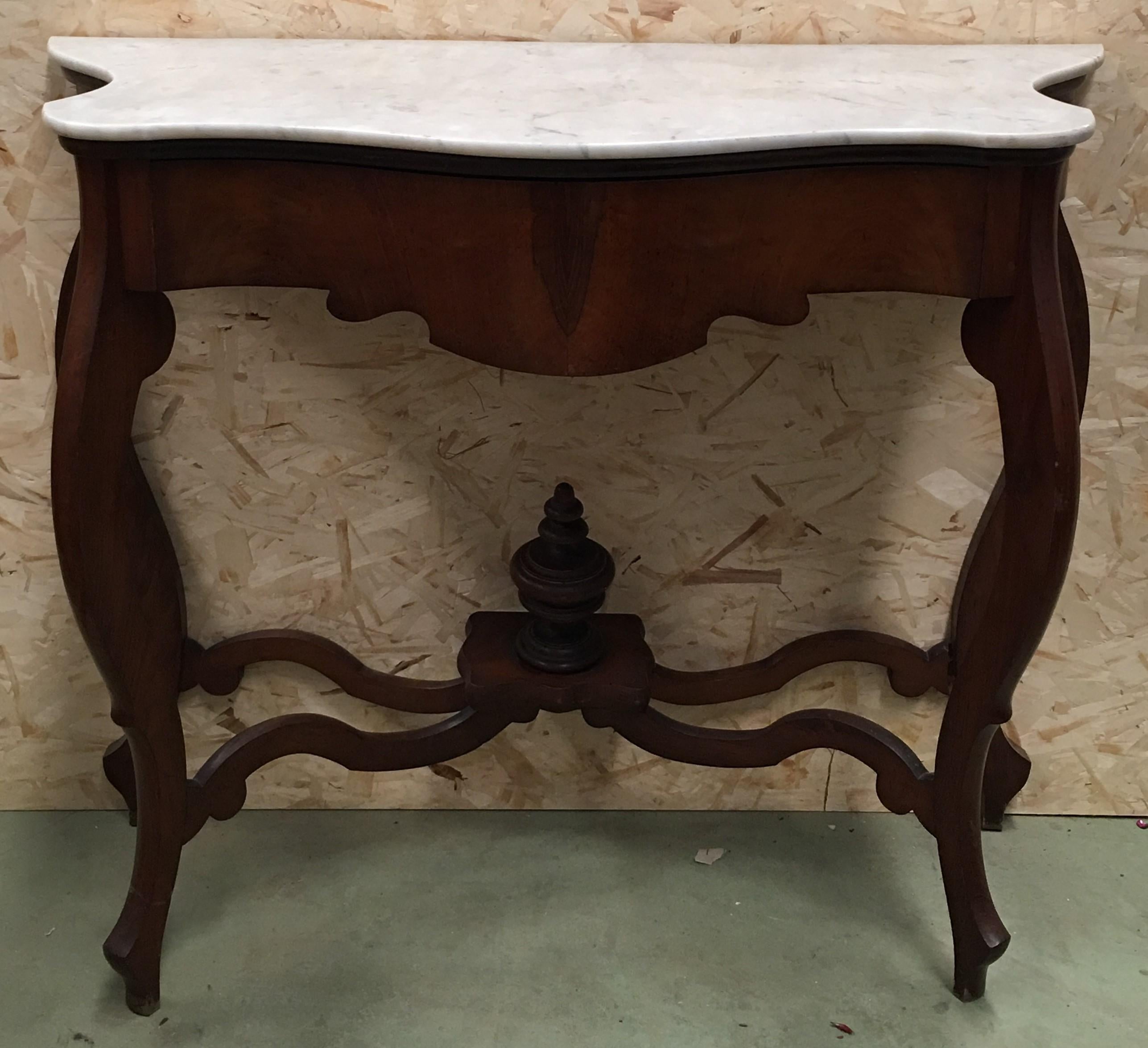 Walnut console table with four curved legs united by an urn stretcher beneath a marble top.