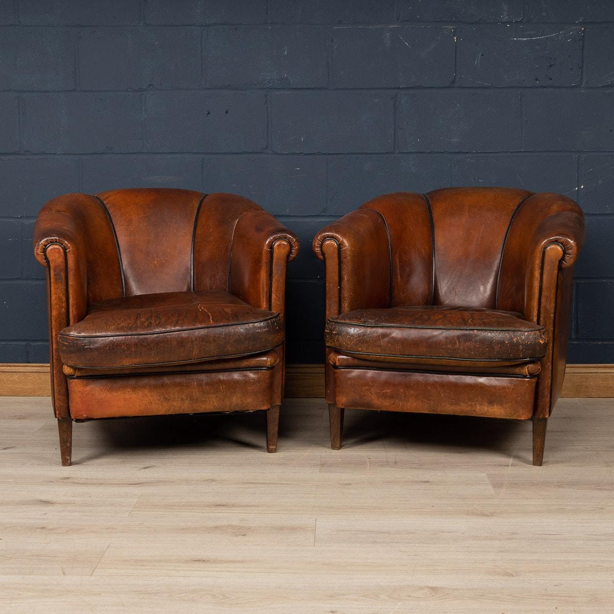 Showing superb patina and colour, this wonderful pair of club chairs were hand upholstered sheepskin leather in Holland by the finest craftsmen in the latter part of the 20th century.

CONDITION
In Average Condition - wear to the seating area.