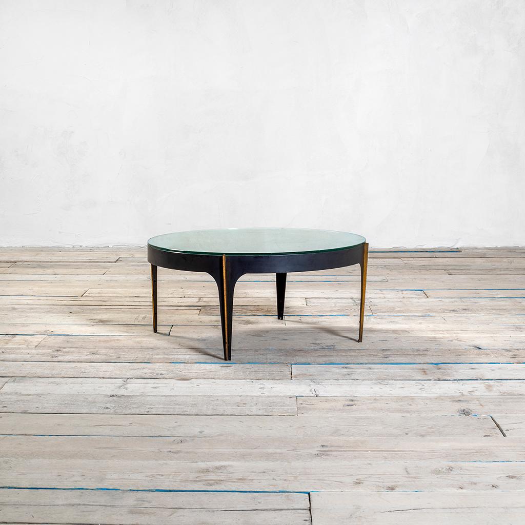 Very rare coffee table designed in 1958 by the great maestro of glass Mr. Max Ingrand for Fontana Arte. 
The table has a structure in black lacquered metal, detail in brass along the four legs and the circular top is composed of a curved mirrored