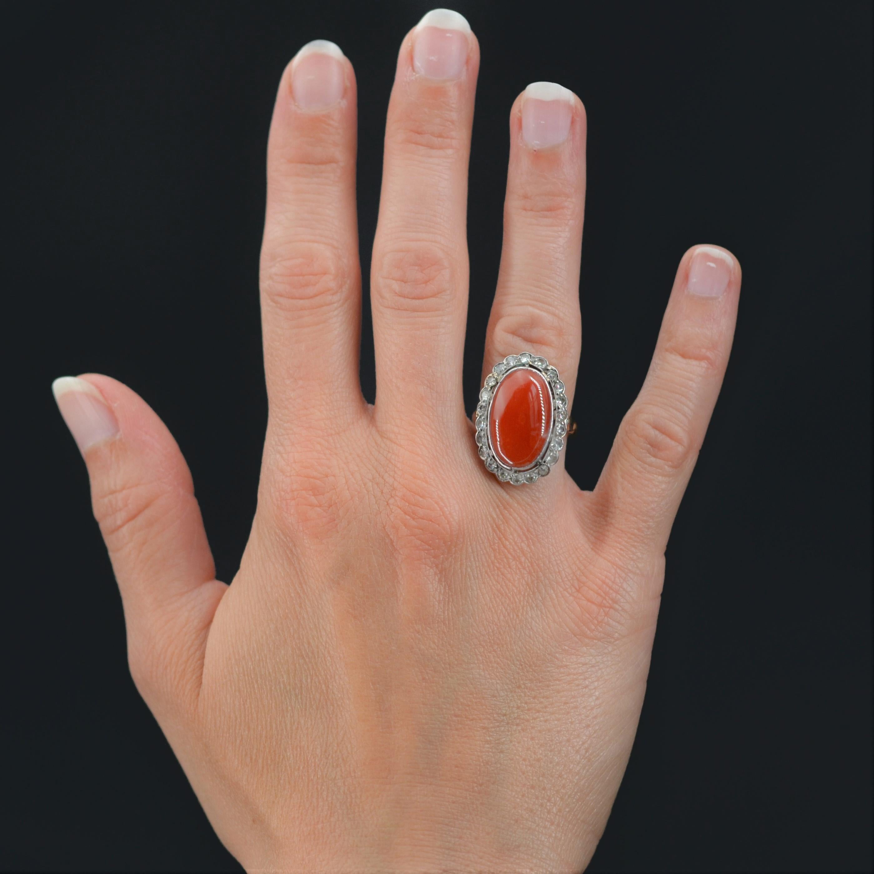 Ring in 18 karat yellow gold, owl hallmark, and platinum.
Pompadour ring, it is decorated in closed setting with a cabochon of Mediterranean coral, in a surround of antique- cut diamonds. The basket is beautifully openworked, and the start of the