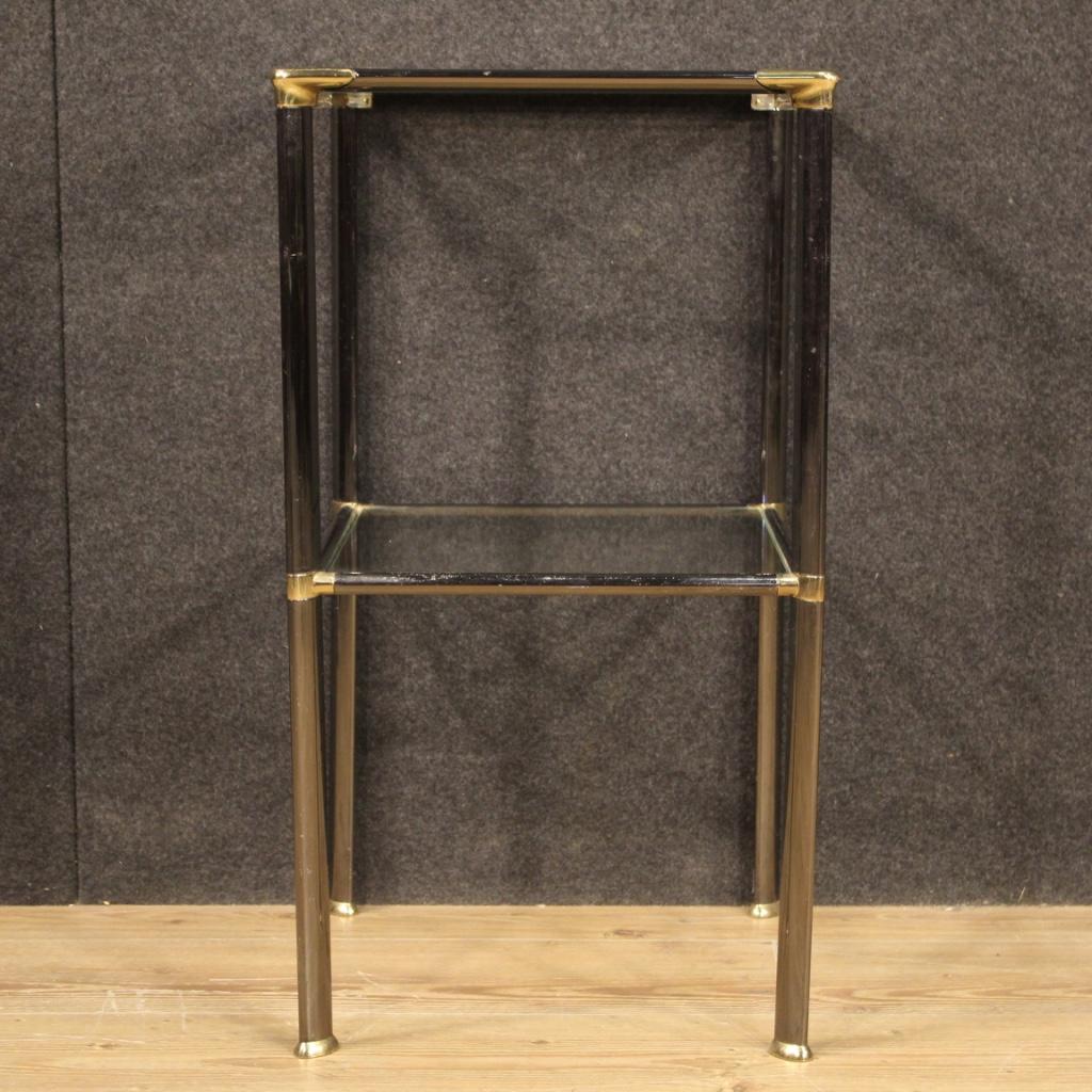 Italian design side table from the 1980s. Silver and gilt metal furniture with two glass shelves. Small size table, of discreet service, it can be easily placed in different points of the house. Furniture with some signs of wear, overall in good