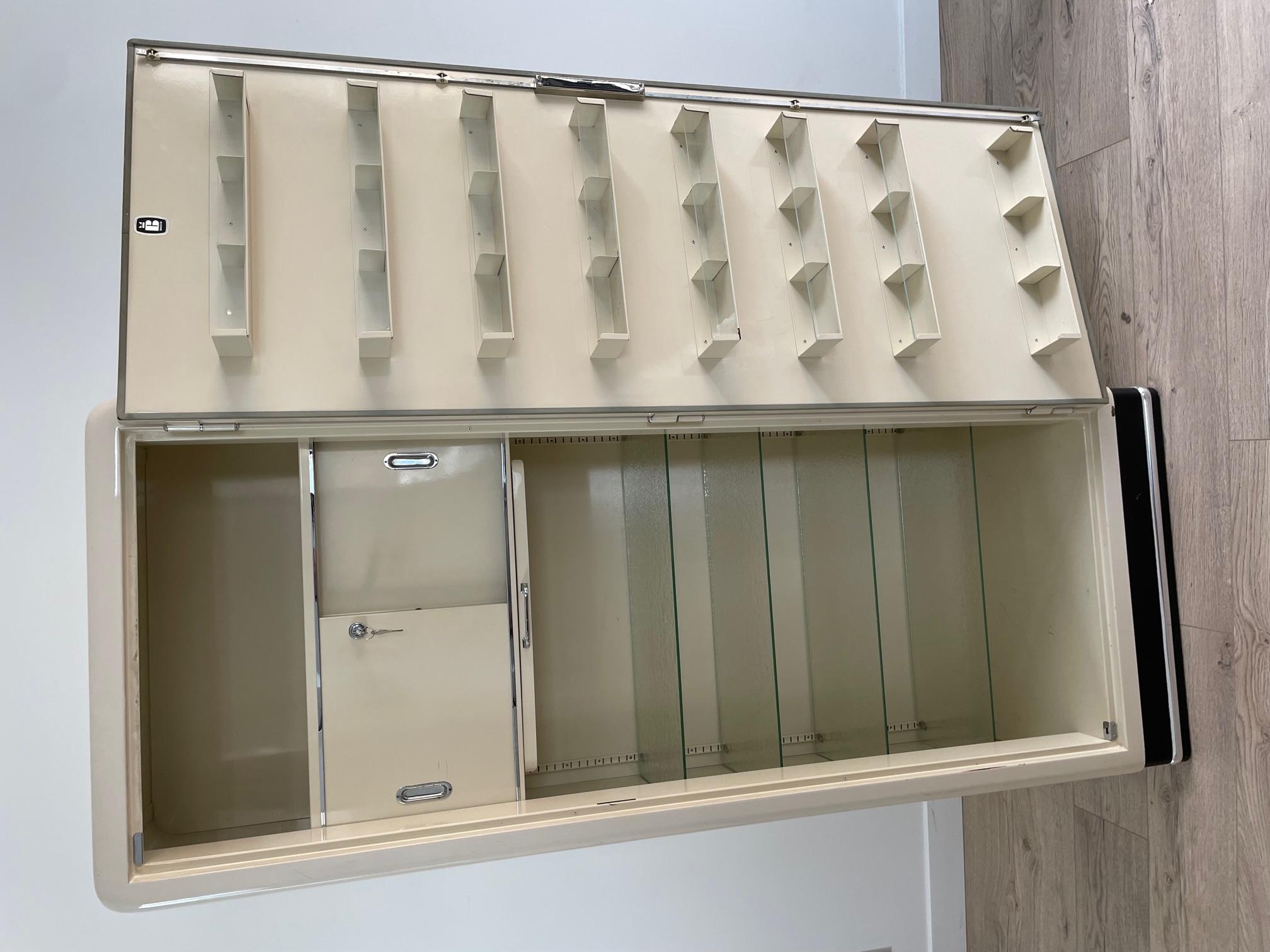 20th Century metal cabinet made in the 1950s for a doctor or dentist office. 
On the inside door, there are many compartment. A sliding door with the key and many glass shelves. Metal chromed handles. 
Very good quality and good condition. 
Made