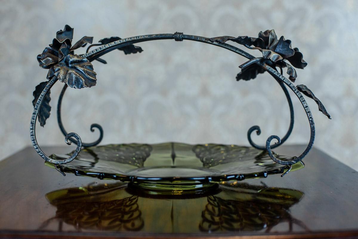 We present you this French epergne composed of an oval plate with a fixed metal handle.
The plate is made of green glass, whereas the handle of iron. It is decorated with the motif of roses.

Presented item is in perfect condition and undamaged.