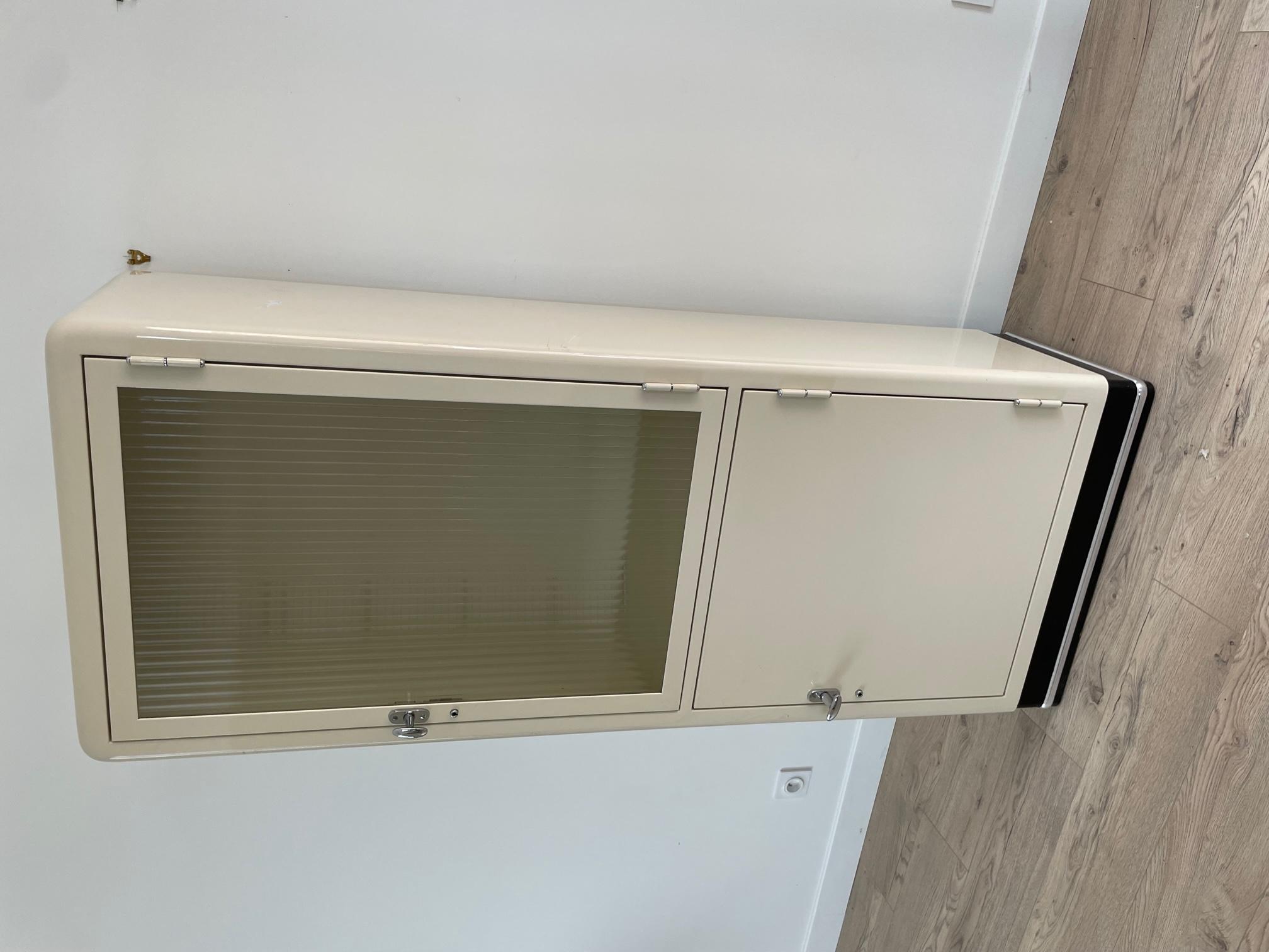 20th Century metal cabinet made in the 1950s for a doctor or dentist office. 
On the inside, there are many glass shelves. Metal chromed handles. 
The door glass is ribbed. 
Very good quality and good condition. 
Made and designed by Baisch, a