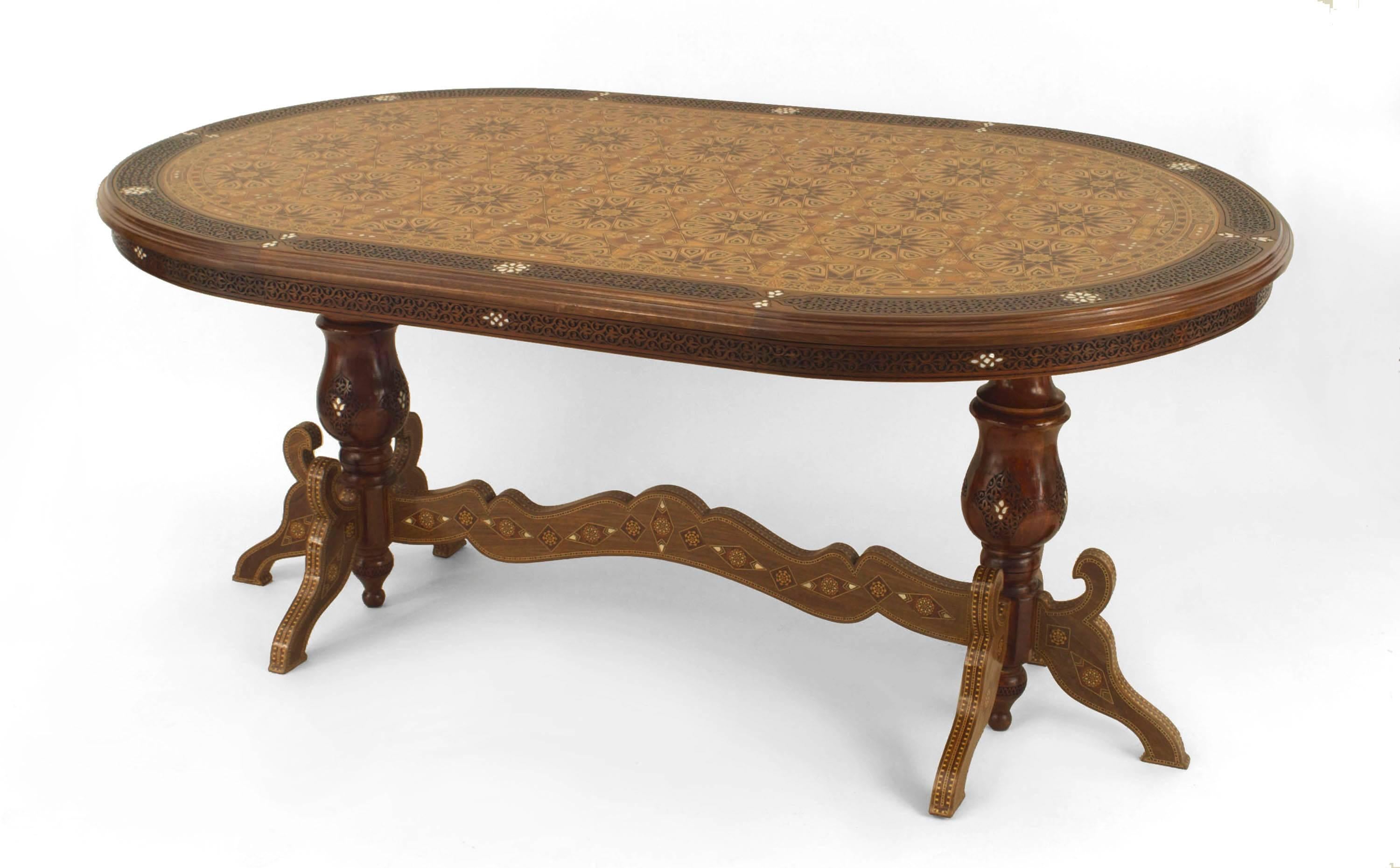 Middle Eastern Syrian (20th Century) oval dining table with a carved fretwork edge and an inlaid geometric design top with 2 pedestal sides connected with a stretcher (Related Items: CON061)
