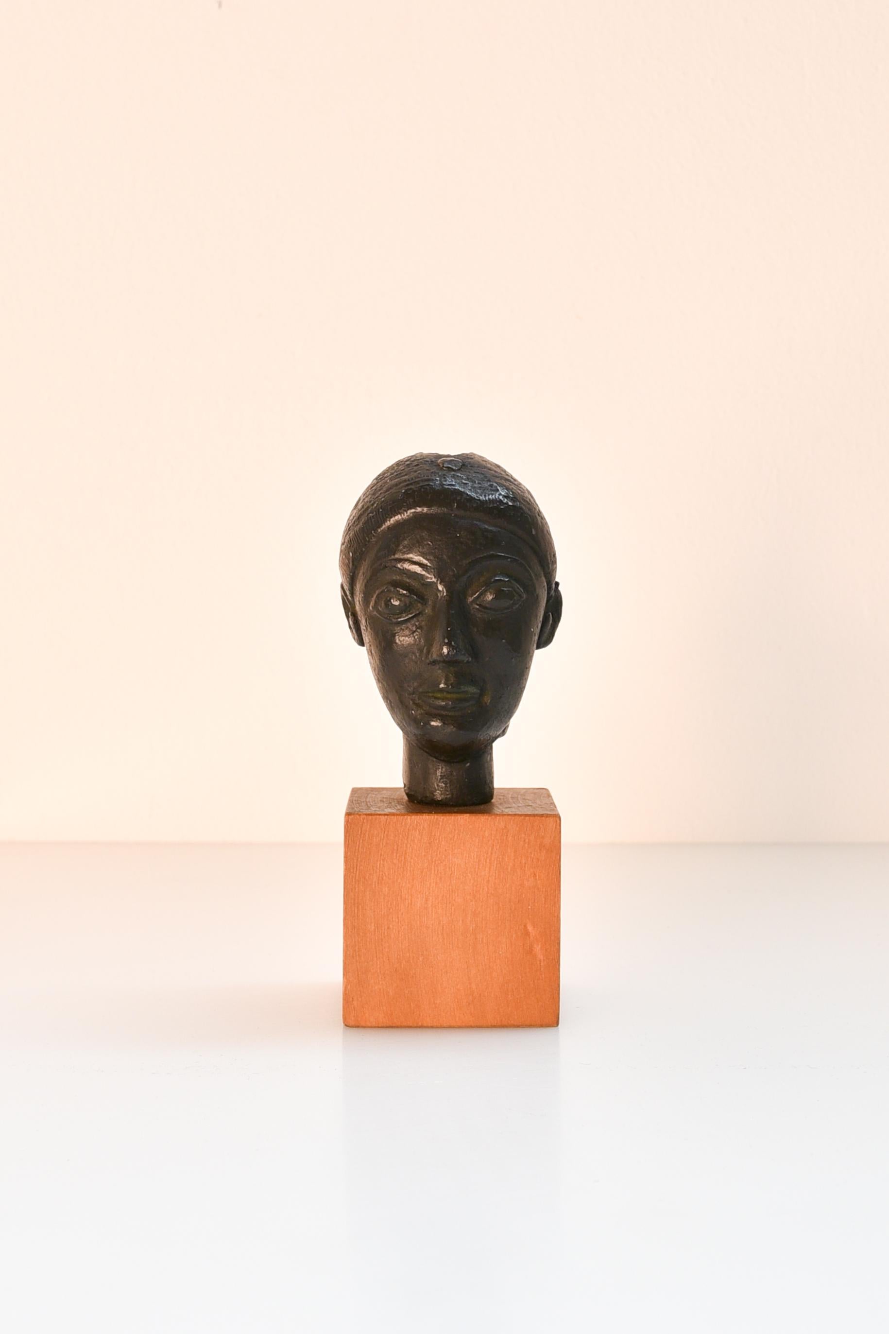 Miniature terracotta head of a woman, mounted on wood  