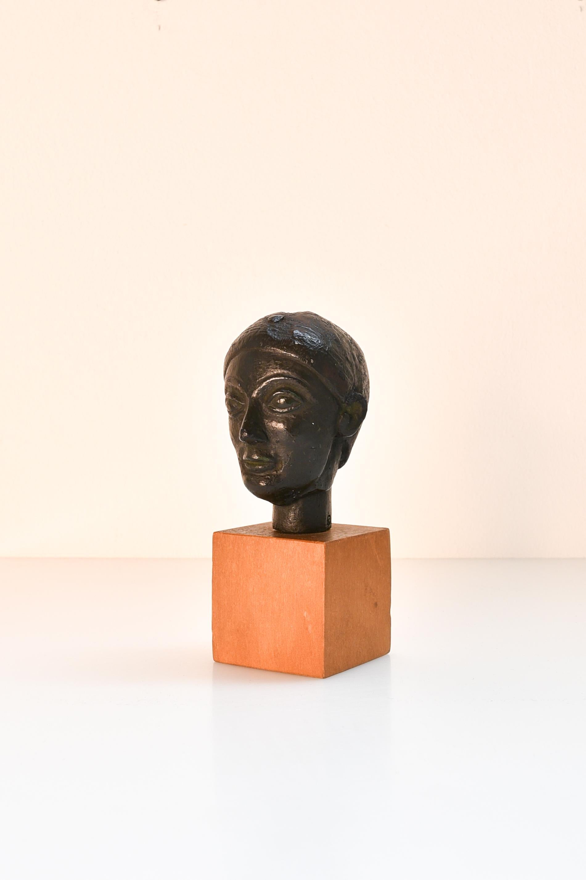 Belgian 20th century miniature black terracotta head of a woman, mounted on wood