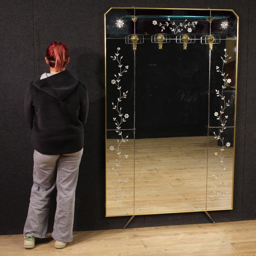 Mid-20th-century Italian mirrored coat rack. Exceptional quality, Italian design with inlaid mirrors and gilded brass accents. The coat rack features four crystal elements for hanging garments and a glass hat rack (see photo). Gilded brass legs and