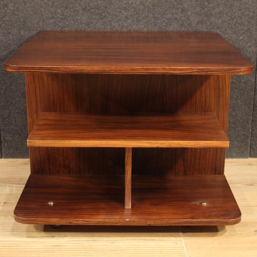 Italian coffee table from the 70s / 80s. Furniture in walnut and palisander woods mounted on swivel castors (see photo). Table of excellent proportion and service equipped with three shelves and two side doors (see photo). Ideal furniture for a