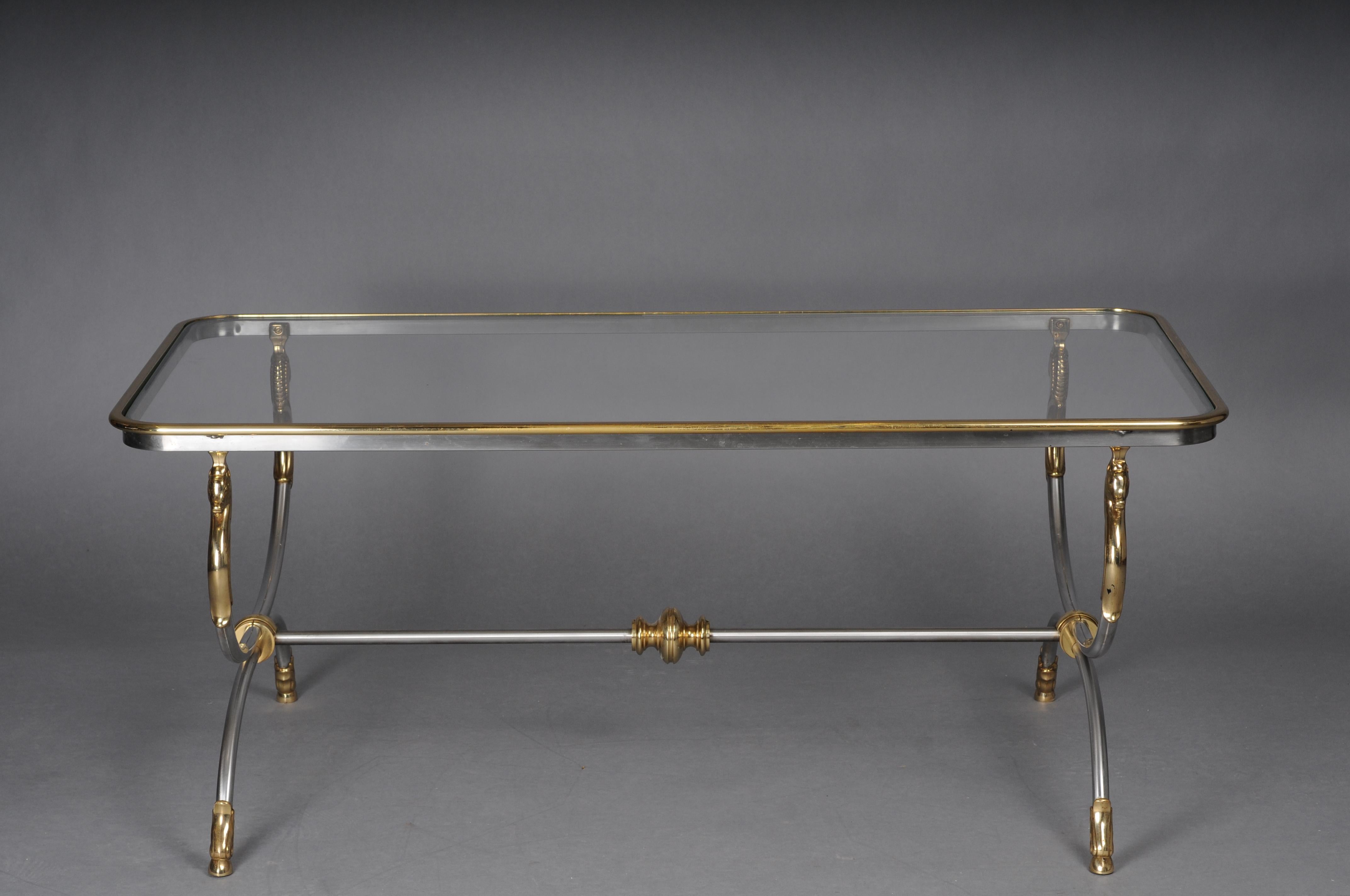 Modern designer coffee table, chrome brass, classical style

Chrome / brass frame, curved and flanked by horse busts in brass. Polished brass frame enclosed in a glass plate.

(A-170).