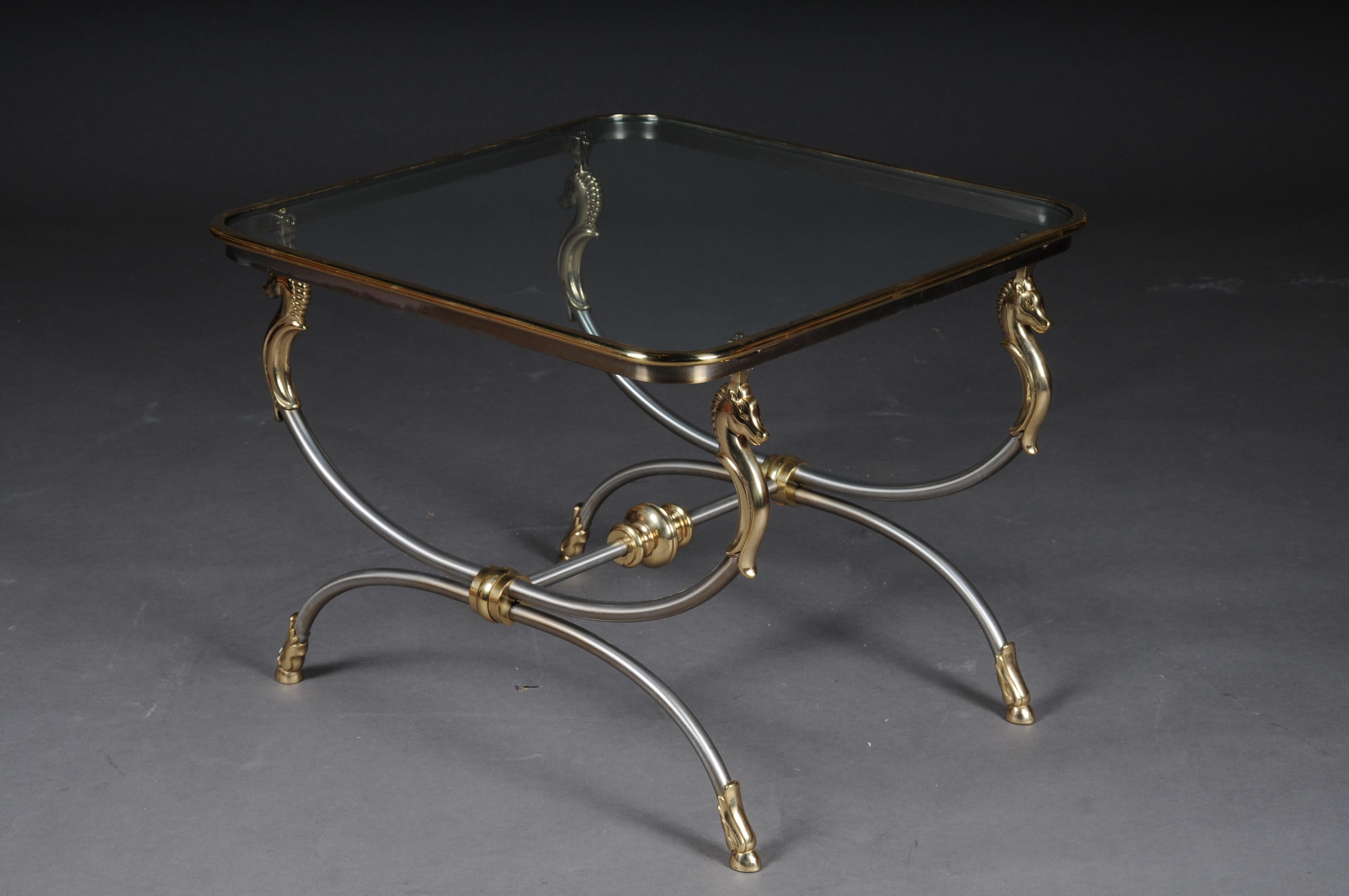 20th century modern designer side table, chrome brass, classical style

Chrome / brass frame, curved and flanked by horse busts in brass. Polished brass frame enclosed in a glass plate.