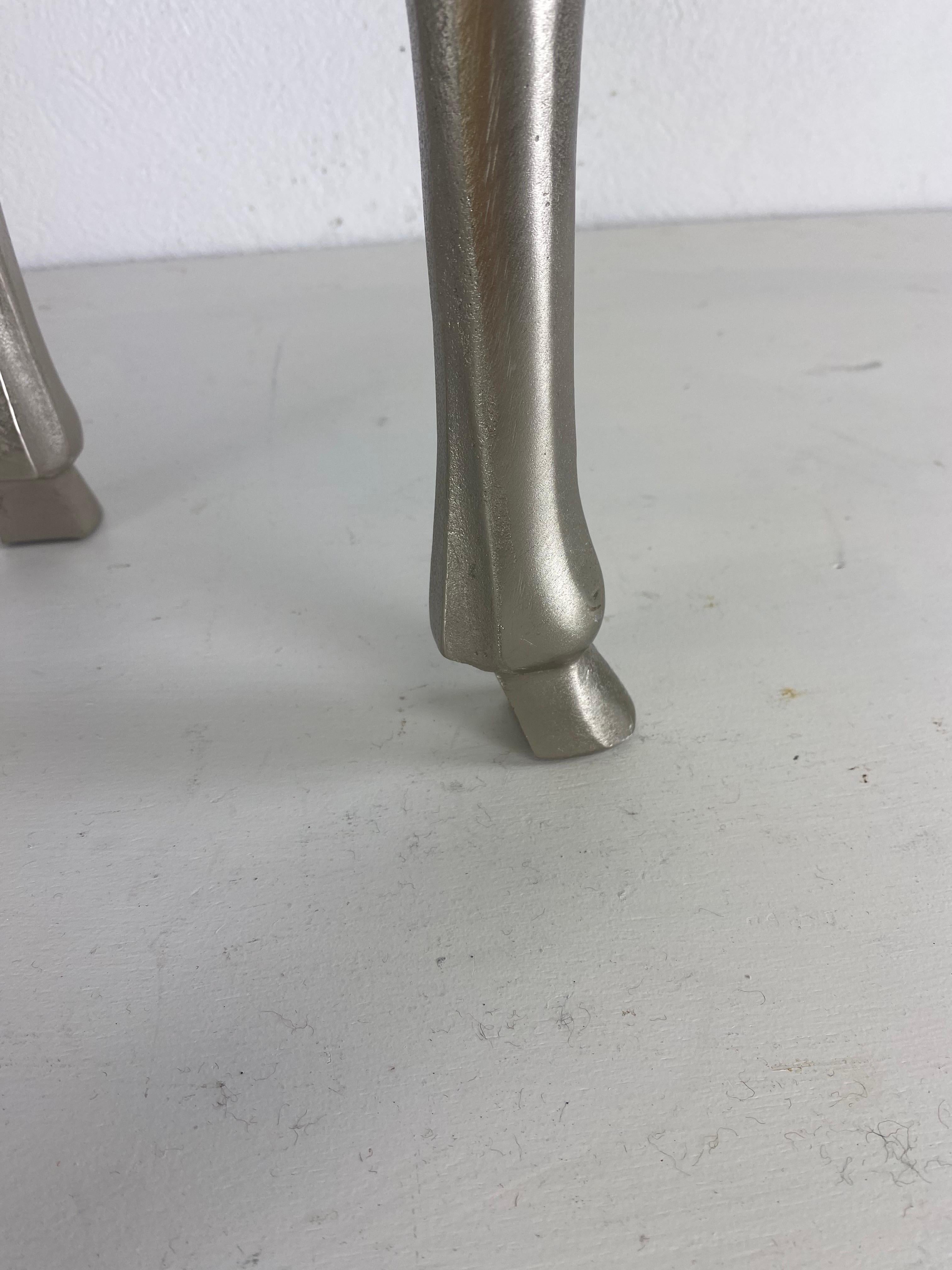 Il s'agit d'un tabouret rembourré d'inspiration Empire datant de la fin du XXe siècle. Le tabouret a été récemment recouvert d'une peau de vache naturelle et repose sur une base en aluminium de style Empire.