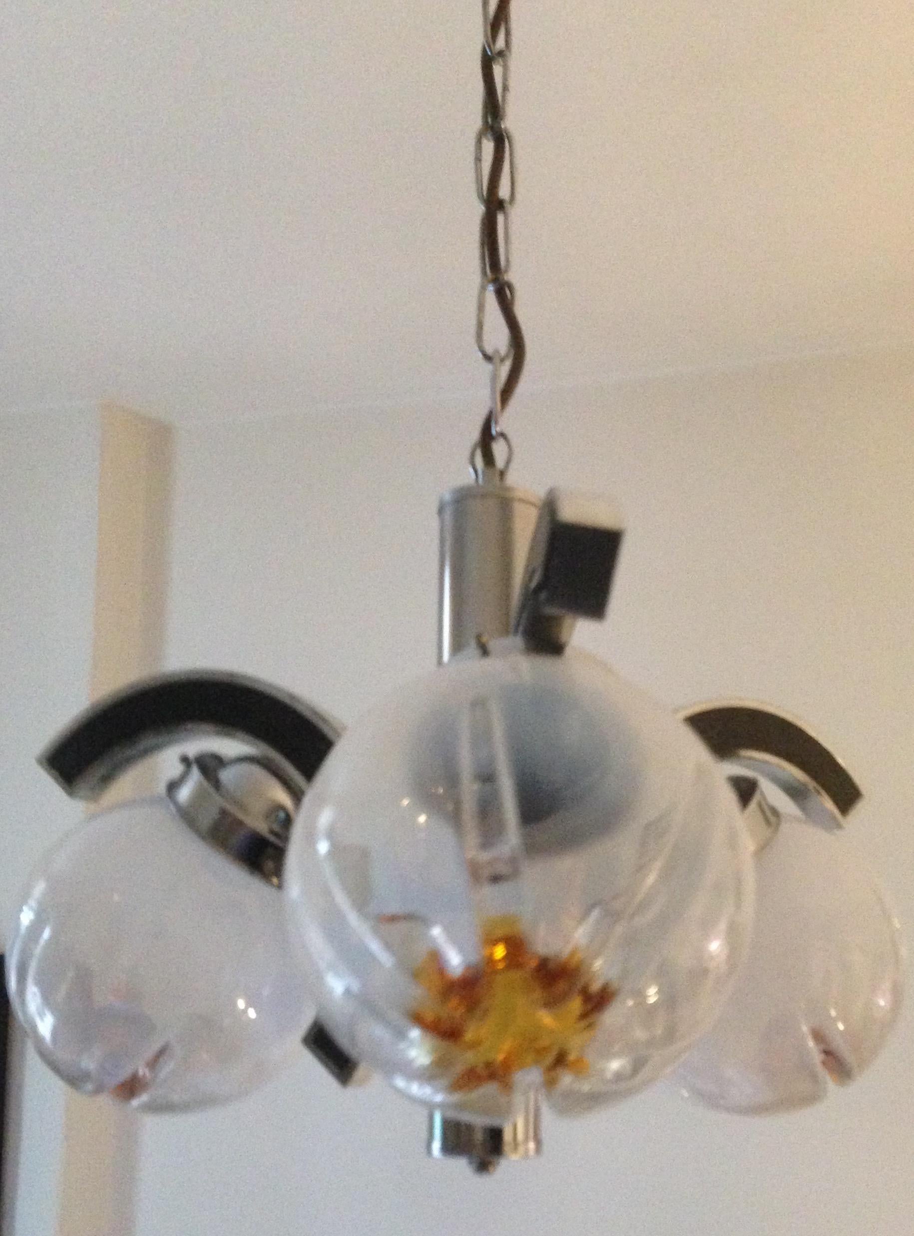 Mid-Century Modern Murano Glass Mazzega chrome and glass chandelier.
Fantastic Mazzega Murano glass and chrome ceiling pendant light. This beautiful light fixture will grace any area of your home with subtle warm light. The glass is handblown and