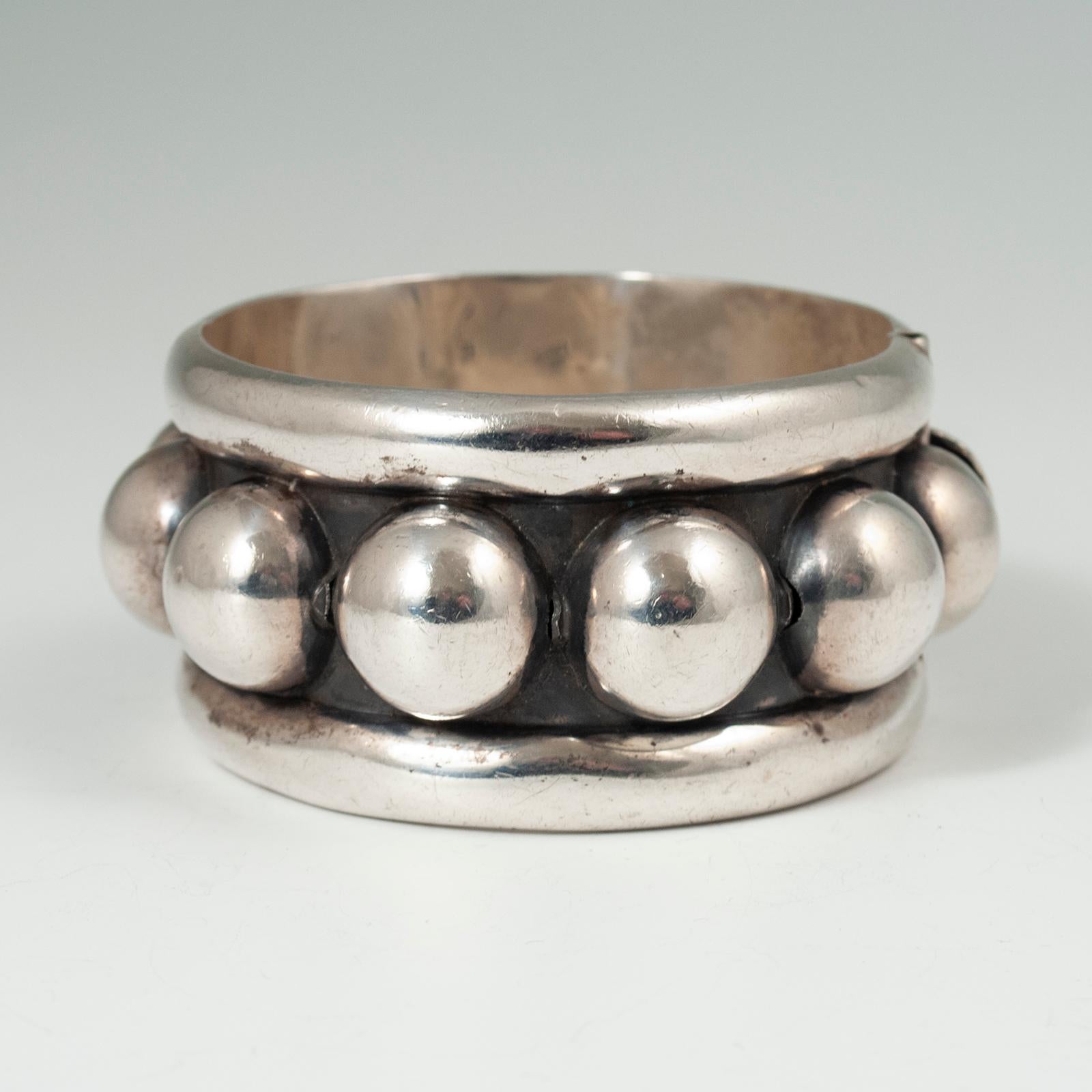 20th century Modern Silver Clamper Bracelet, Taxco, Mexico

A modern dotted silver hinged bracelet from Taxco, Mexico. Marked MEXICO 825 on the interior. Diameter is 2-5/8 inches with an interior circumference of 8-7/8 inches, weighs 116 grams.