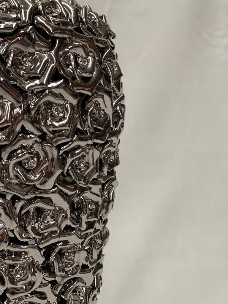 Meisterwerk aus Messing in Silber gegossen. Die Vase ist mit kleinen klassischen Rosen bedeckt. Es ist ein klassisches Stück mit einer gewissen Modernität. 
Entworfen von Domenico Mice