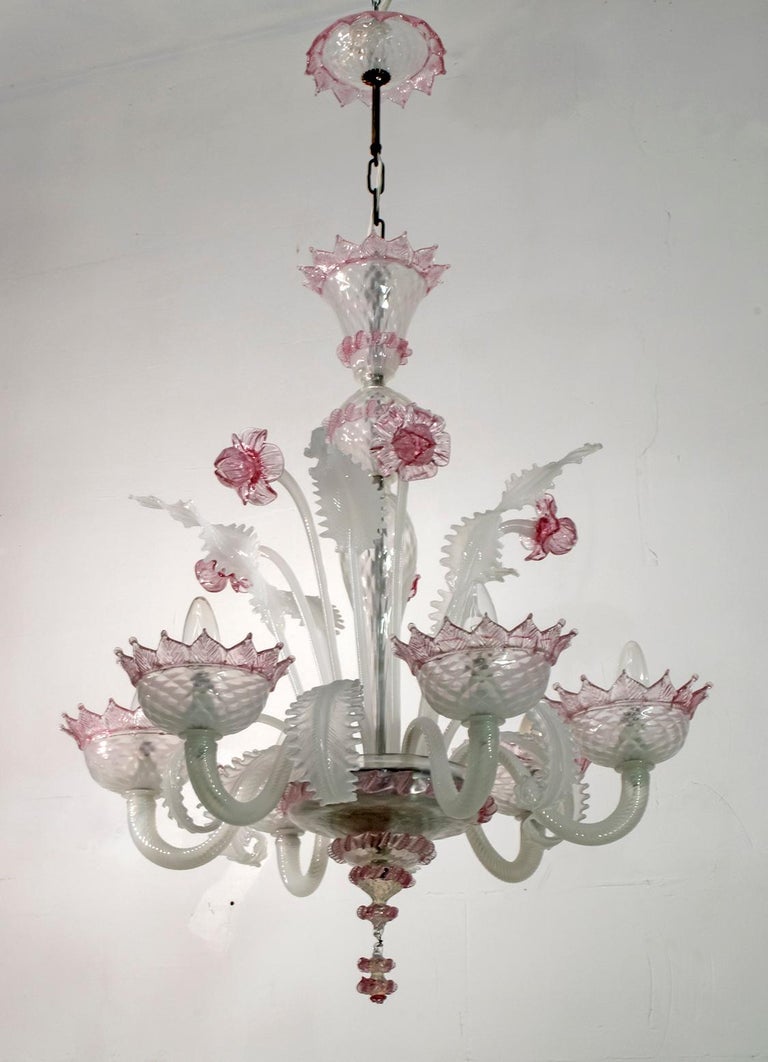 An elegant six-light chandelier in milk-colored Murano glass and sophisticated pink finishes. With a centered bulbous column that emits branches and flowers and finely cuts the Murano glass leaves.

Ca'Rezzonico is the name of a Venetian palace,