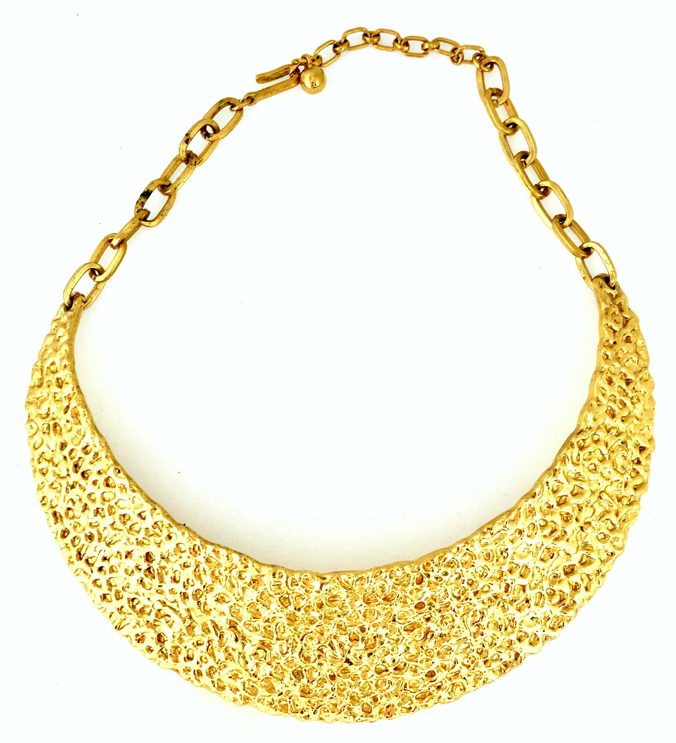 20th Century Rare Modernist Gold Plate Hammered Collar Choker Style Necklace By, Trifari. Features a gold hammered curved collar plate with a chain link adjustable clasp. Signed on the hook clasp, Trifari.
Hammered collar plate measures, 5.75