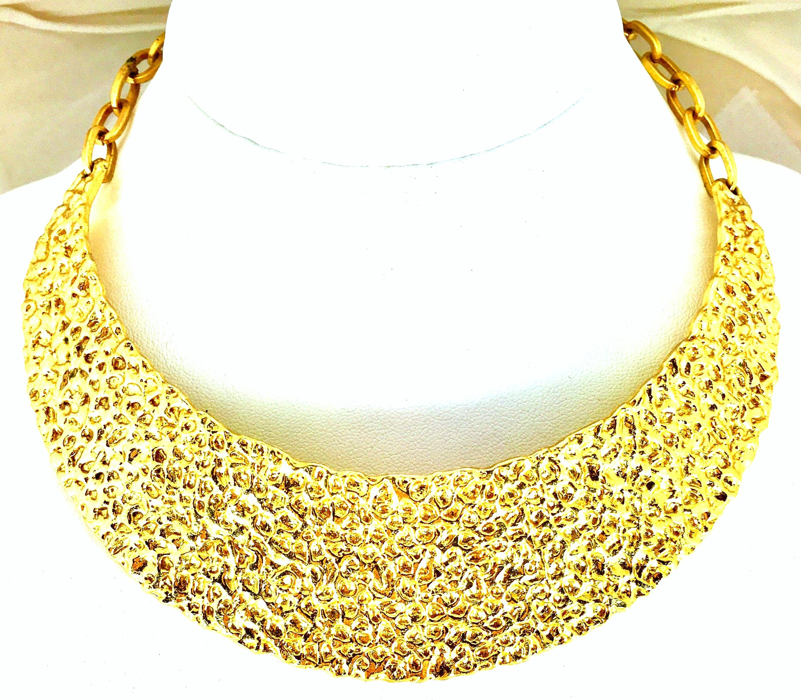 20th Century Rare Modernist Gold Plate Hammered Collar Choker Style Necklace By, Trifari. Features a gold hammered curved collar plate with a chain link adjustable clasp. Signed on the hook clasp, Trifari.
Hammered collar plate measures, 5.75