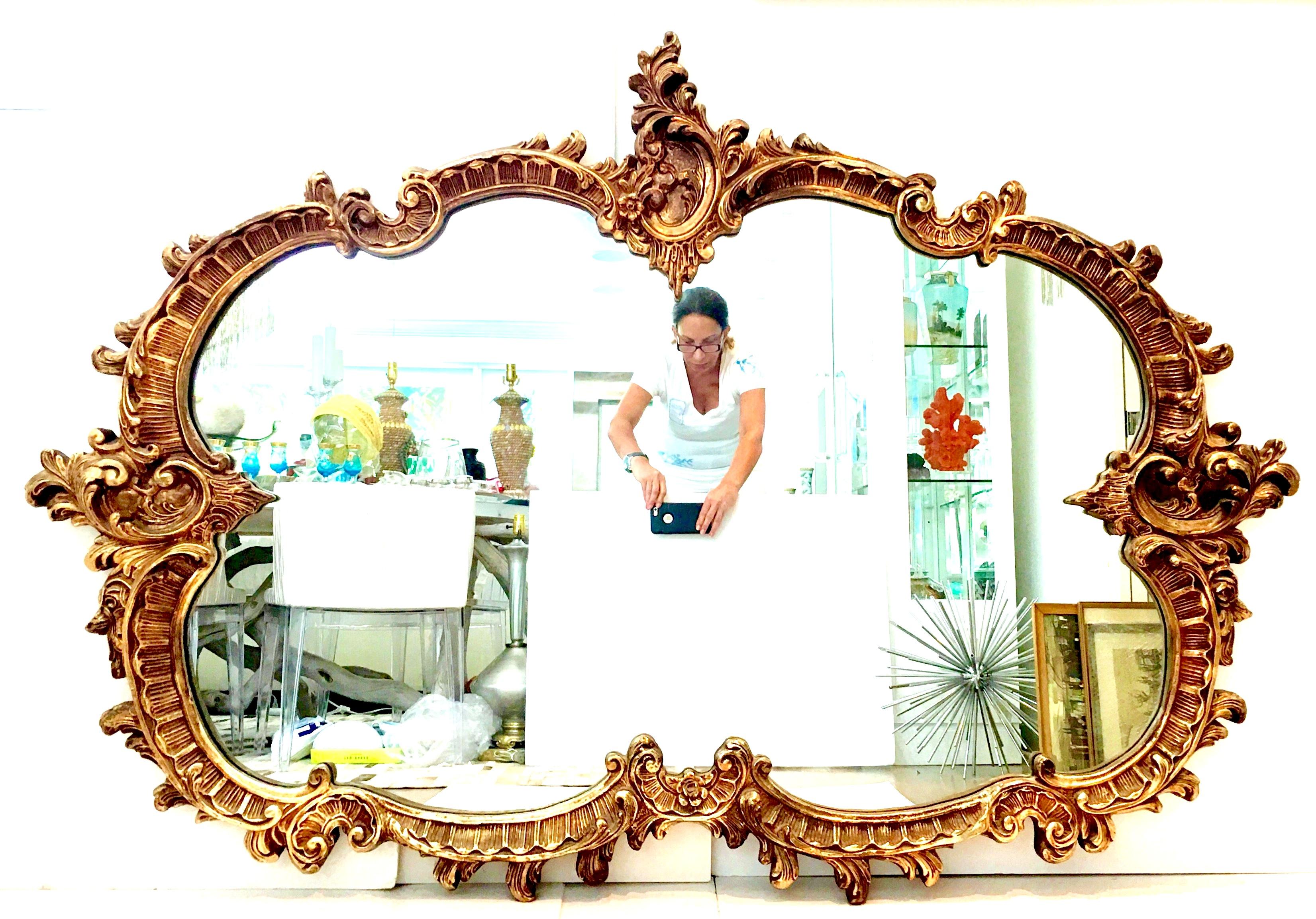 Mid- 20th Century Monumental & Dramatic French Baroque style 6' foot carved gilt wood and composite mirror This six foot mirror features Classic French molding motifs, acanthus leaf, cartouche, rosettes and gardrooned leaf detail. Perfect for over