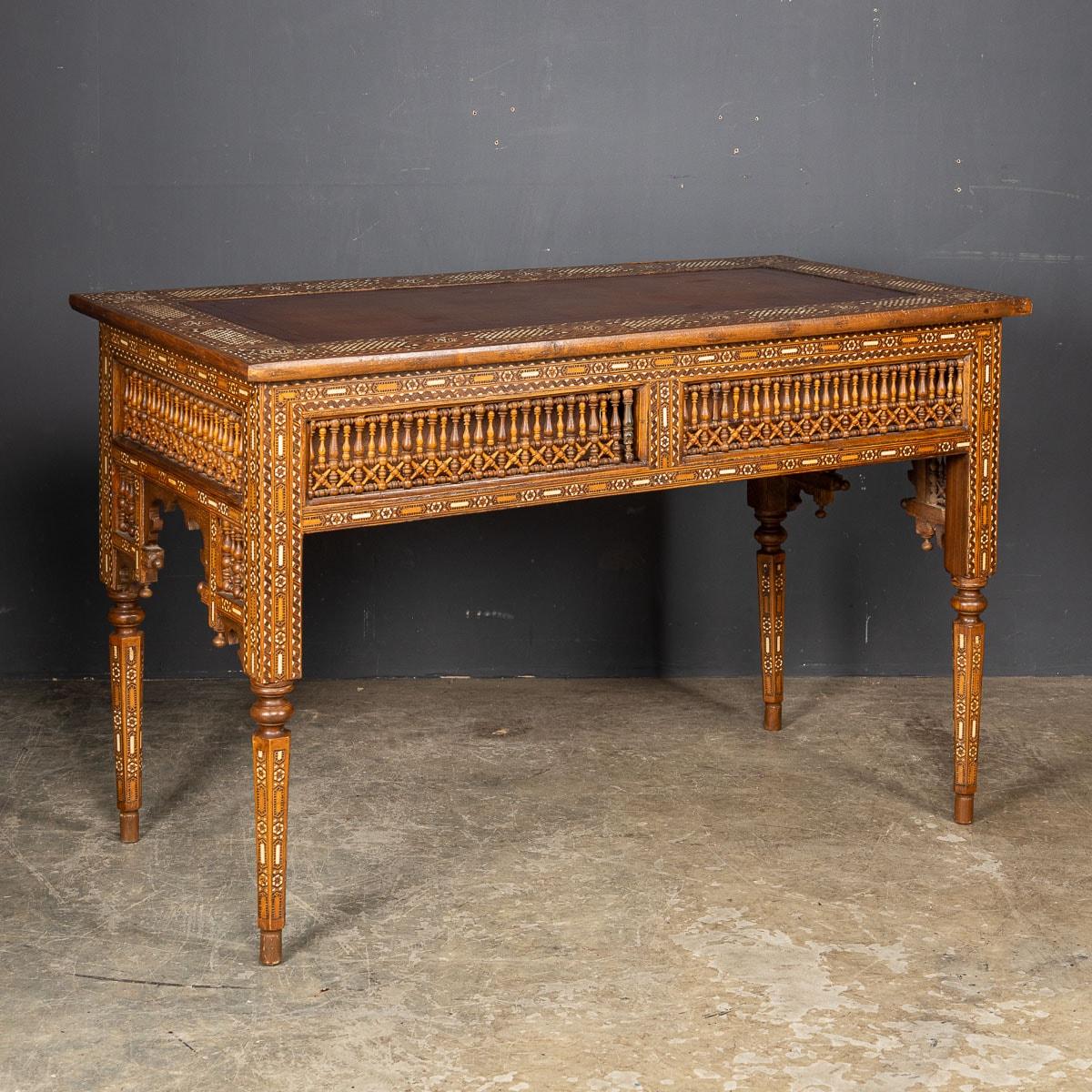 Crafted in the early 20th Century, this Levantine inlaid table is a true testament to artistry and craftsmanship. It features two discreetly concealed drawers along with a leather lined top. It's meticulously handmade from sturdy hardwood. The