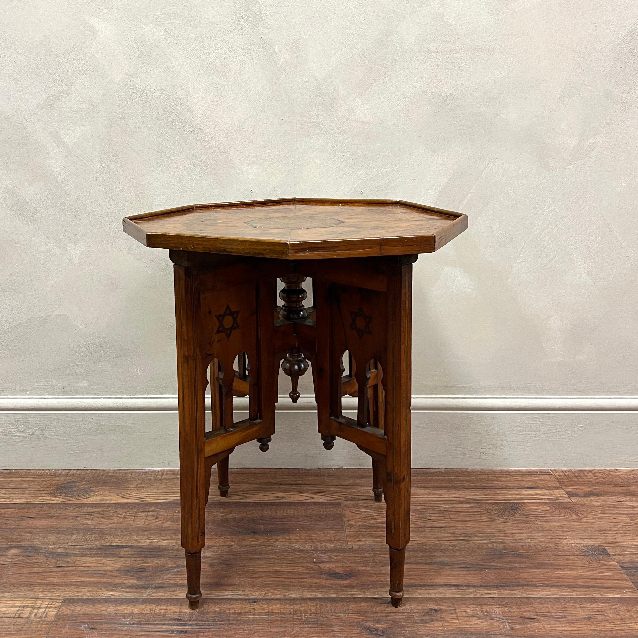 A hexagonal side table with inlay detail, made from burr walnut veneer. sitting on 4 legs with a detailed carved design and a central finial.
No losses but has aged very well.

Morocco, circa 1920.

Height -62.5cm
Diameter -54.25We are happy to work