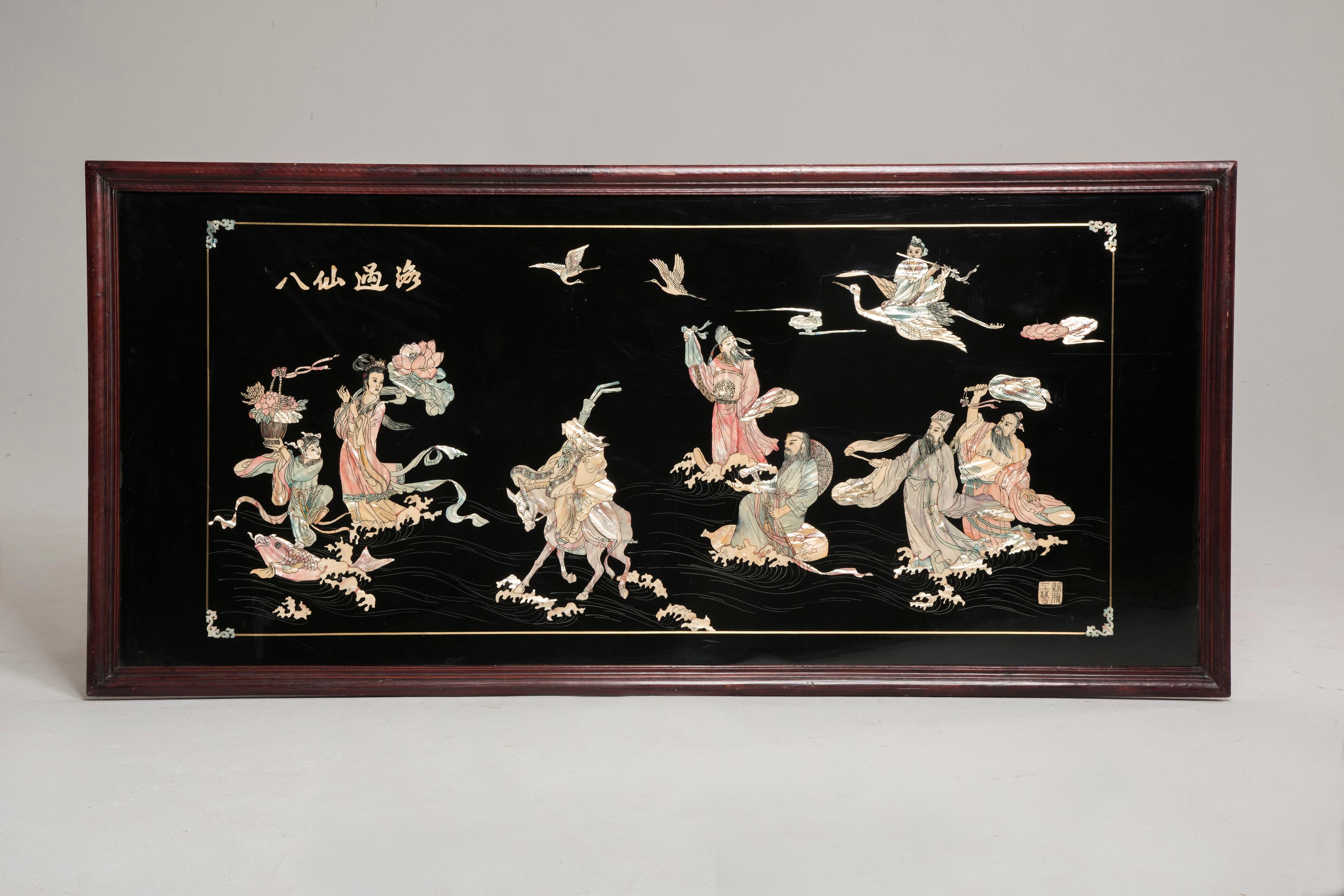 Decorative chinoiserie panel.
It features dark background, mother of pearl inlays and wood lacquered frame. This panel represents traditional Chinese scenes and characters, wearing traditional clothes. Traditional animals from the Chinese culture