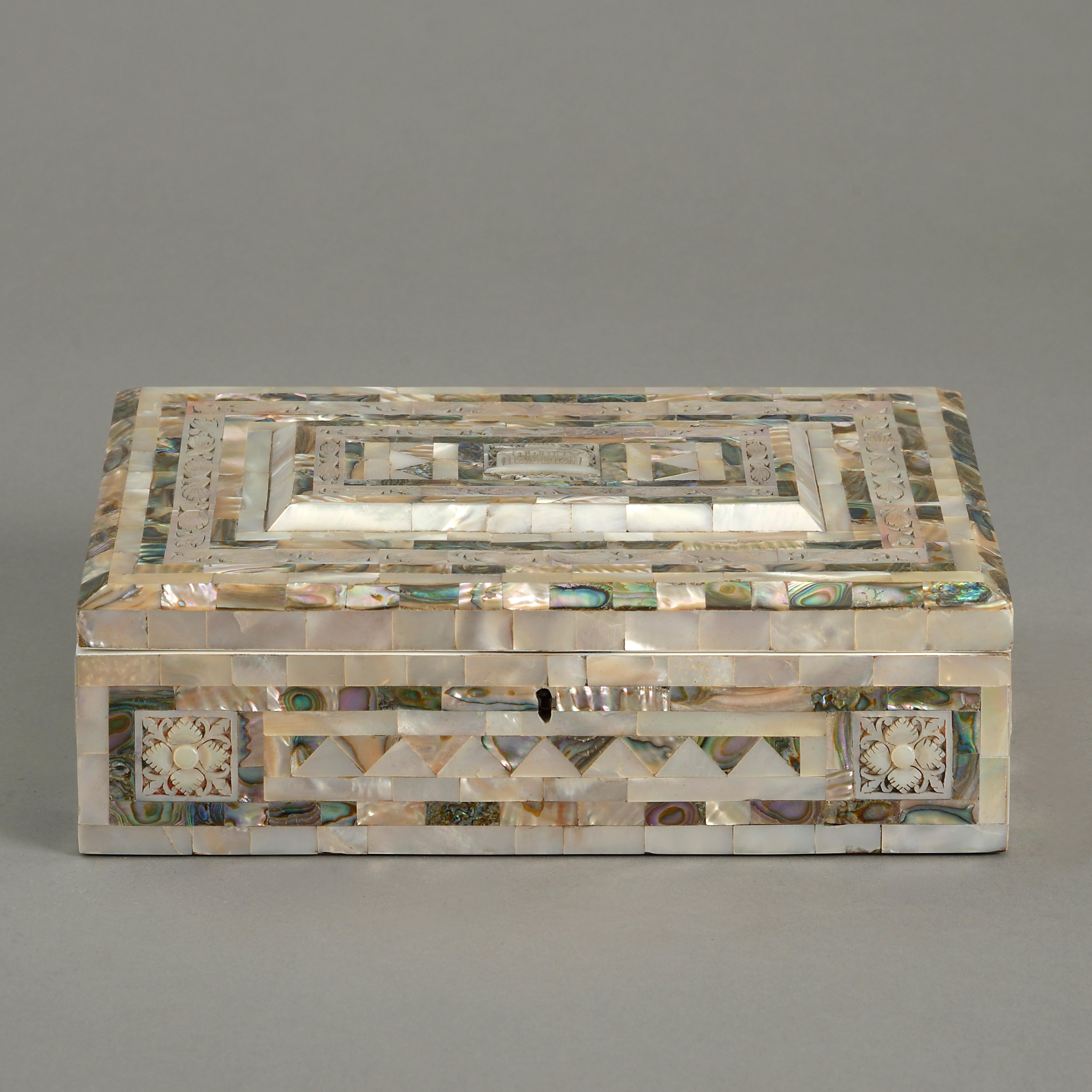An early 20th century jewelry box of rectangular form, veneered throughout in carved and polished mother of pearl panels, opening to reveal the original pink silk lined interior.