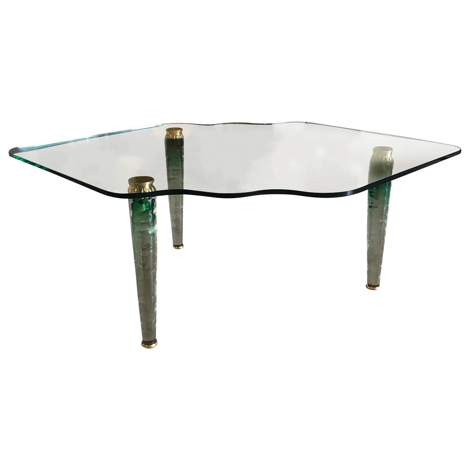 A vintage Mid-Century Modern Italian green tinted coffee table made of hand blown Murano glass and brass in the style of Danny Lane. Green glass top on three ombre green tapered legs. Wear consistent with age and use. Minor losses on one leg, circa