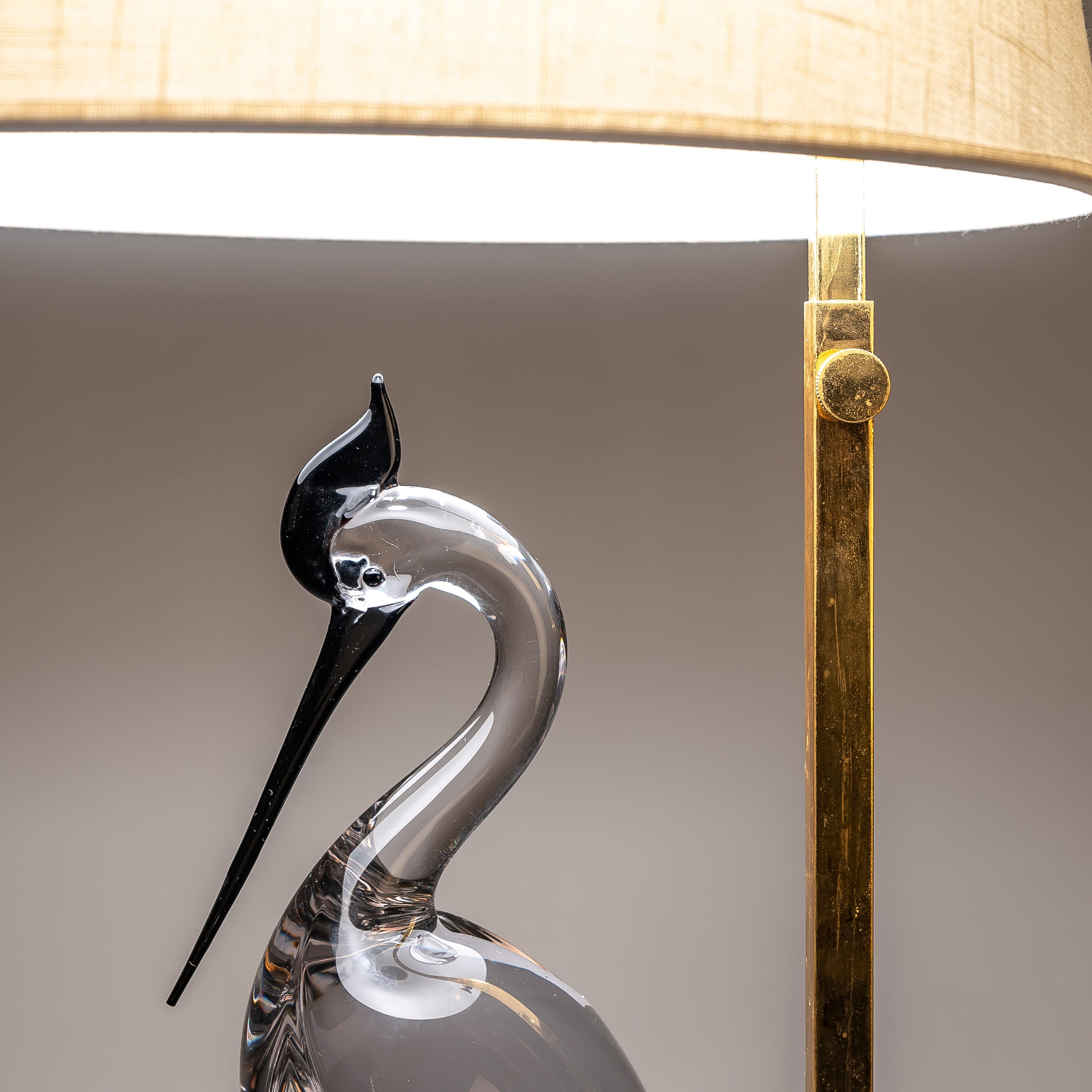 This 20th Century Murano glass and brass Heron table lamp from Italy, crafted in the 1970s, is a captivating blend of artistry and functionality that can transform any space into a sanctuary of elegance.

At first glance, the lamp's striking design