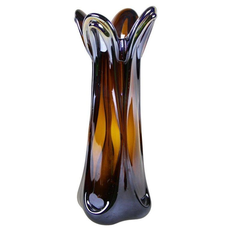 Unique en son genre, ce vase en verre de Murano est d'une beauté exceptionnelle. Il date de la fin du 20e siècle, vers 1960/70, en Italie. Ce superbe vase en verre de Murano présente un design unique, un corps de couleur ambre avec un extraordinaire