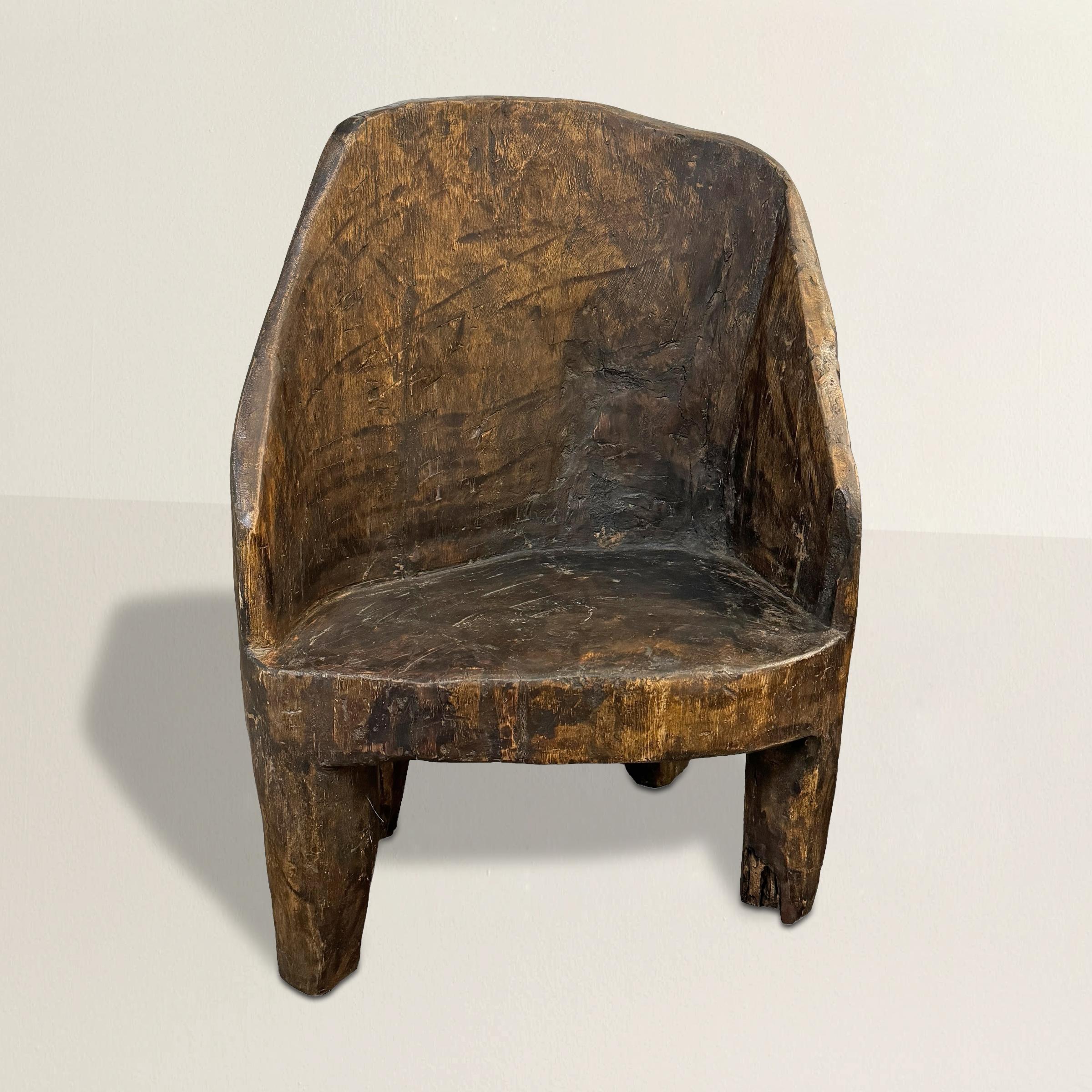 Esta silla del siglo XX, tallada a mano en una sola pieza de madera por el pueblo Naga de la India, es una notable mezcla de encanto primitivo y espíritu moderno. El pueblo Naga, conocido por su rico patrimonio cultural y su hábil artesanía, ha