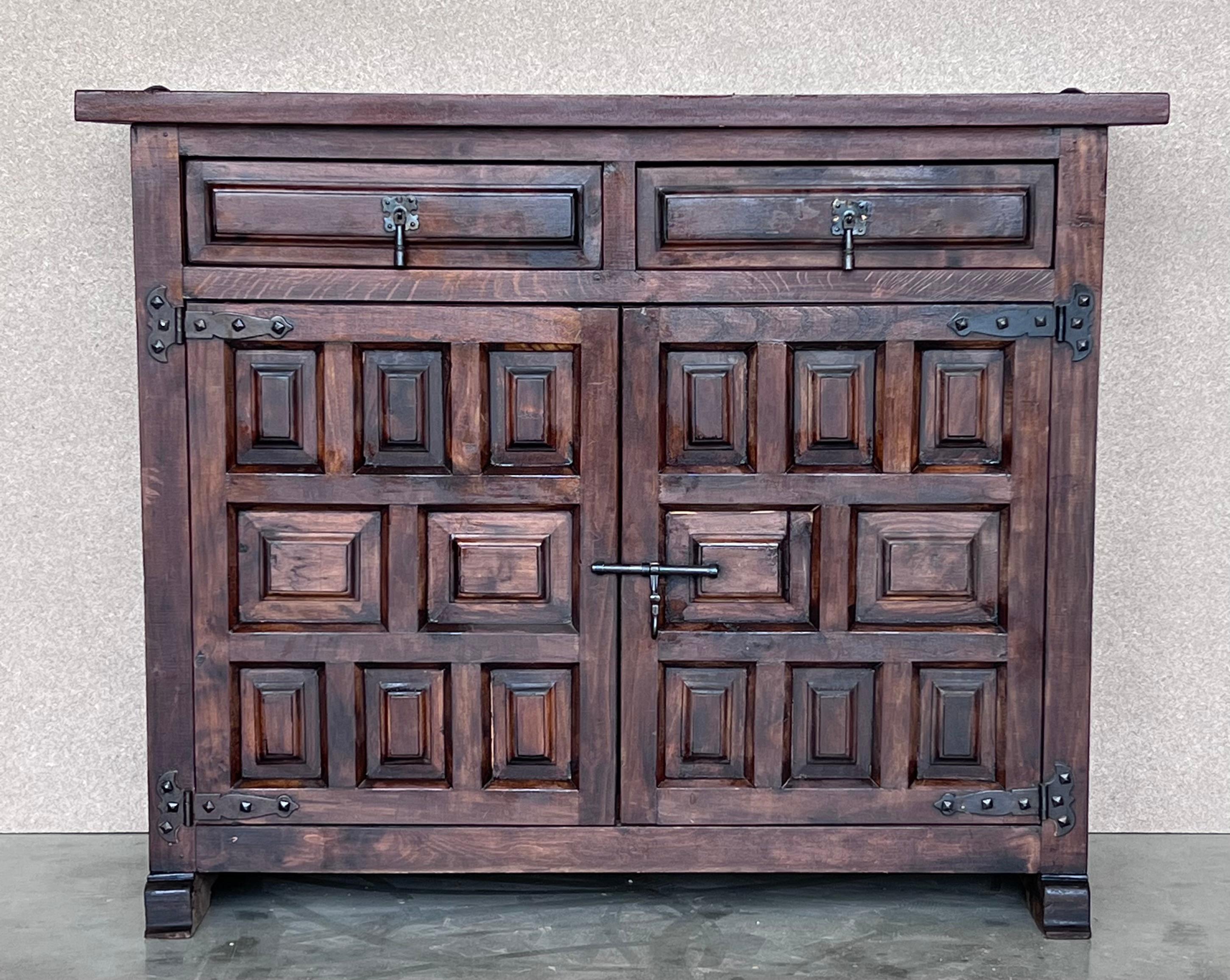 From Spain, constructed of solid walnut, the rectangular top without edge top, conforming case housing two carved drawers with two doors paneled with solid walnut, raised on a plinth base.
Very heavy and original cabinet.