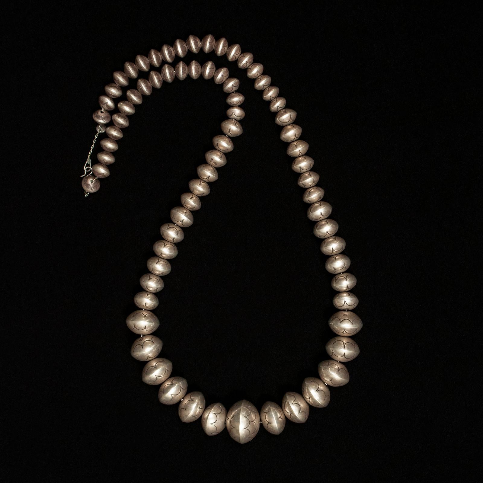 20th century Native American silversmith Leo Yazzie silver pearl necklace

This Navajo pearl necklace contains 73 beautifully graduated beads and is 37 inches long. The diameter of the largest bead is 1.25 inches and the entire necklace weighs 206