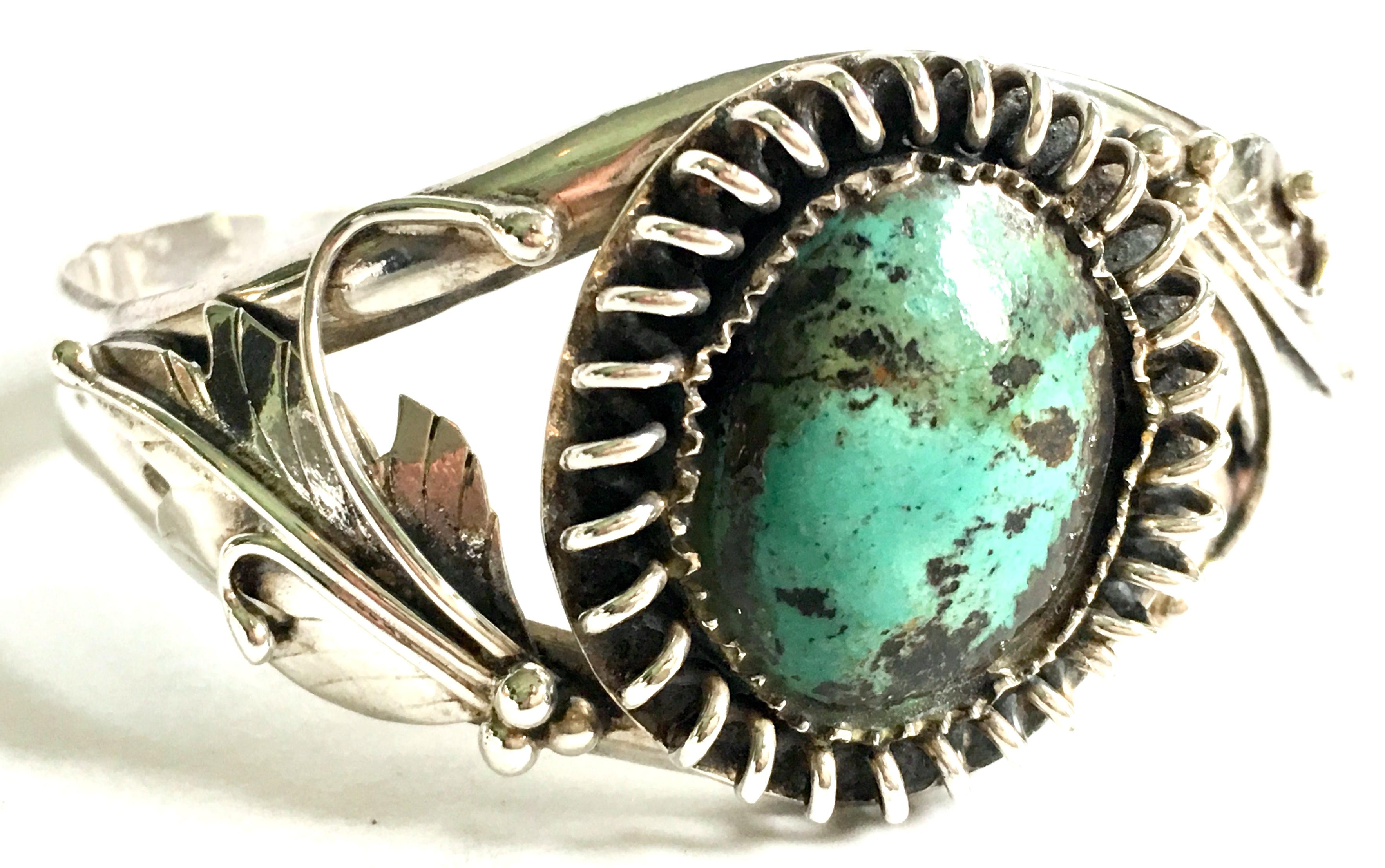 Mid-20th Century Navajo 925 Sterling Silver & Turquoise Cuff Bracelet. This unique and one of a kind piece features a central asymmetrically bezel set central stone surrounded by dimensional sterling coil open work detail. The sterling bracelet is