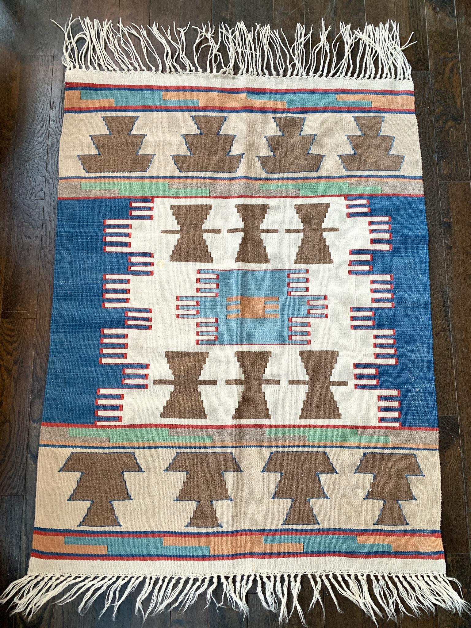 Navajo rug with an earthy palette of light and dark blues, red, pale green, brown, tan, peach, and ivory. 

Dimensions:
3' x 4' (36 in. x 48 in.)

Condition notes:
In good condition. Light wear to pile and minor staining, all consistent with the